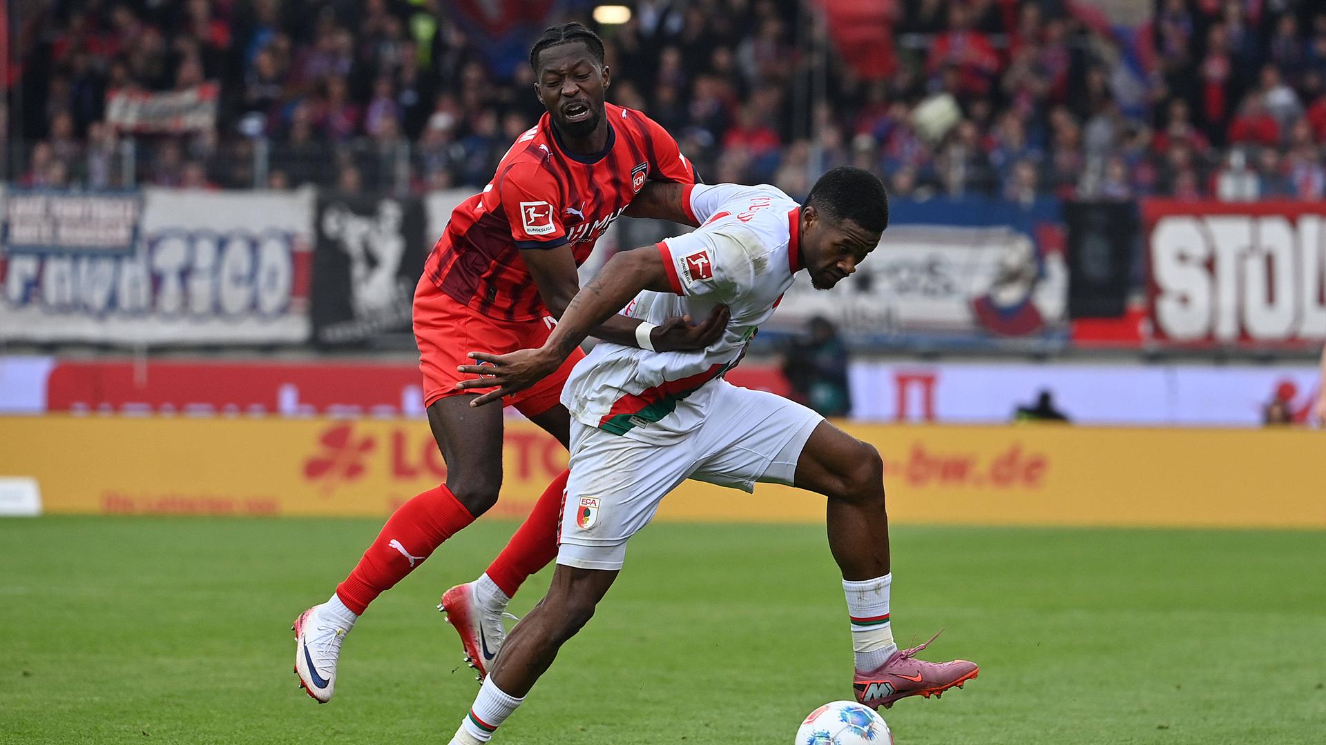 Zweikampf um den Ball zwischen Augsburgs Samuel Essende und Heidenheims Omar Haktab Traore.