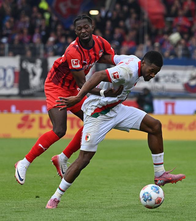 Zweikampf um den Ball zwischen Augsburgs Samuel Essende und Heidenheims Omar Haktab Traore.