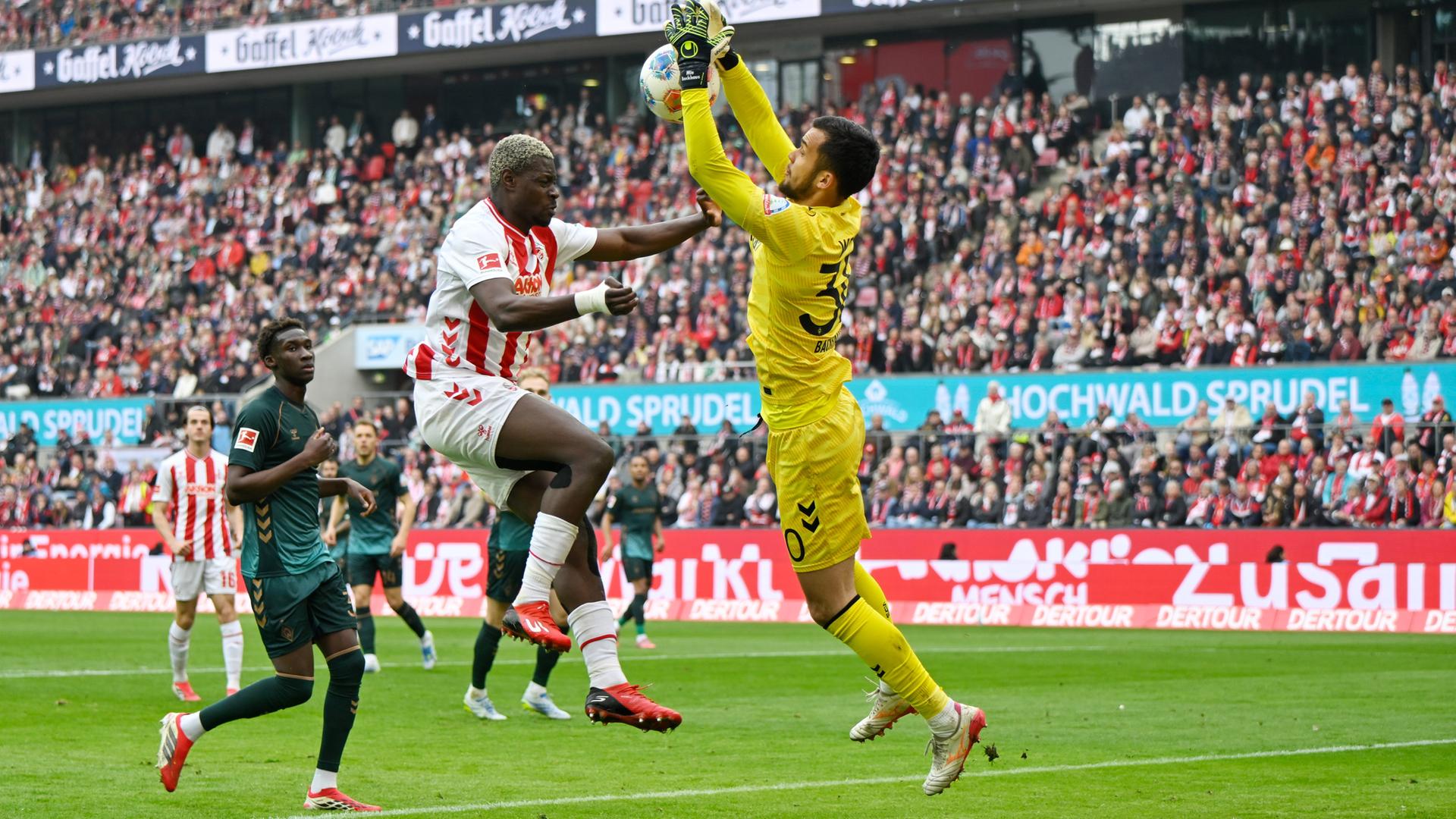 v.l. Ragnar Ache (Köln) und Torwart Mio Backhaus (Bremen) am 12.04.2026 in Köln.