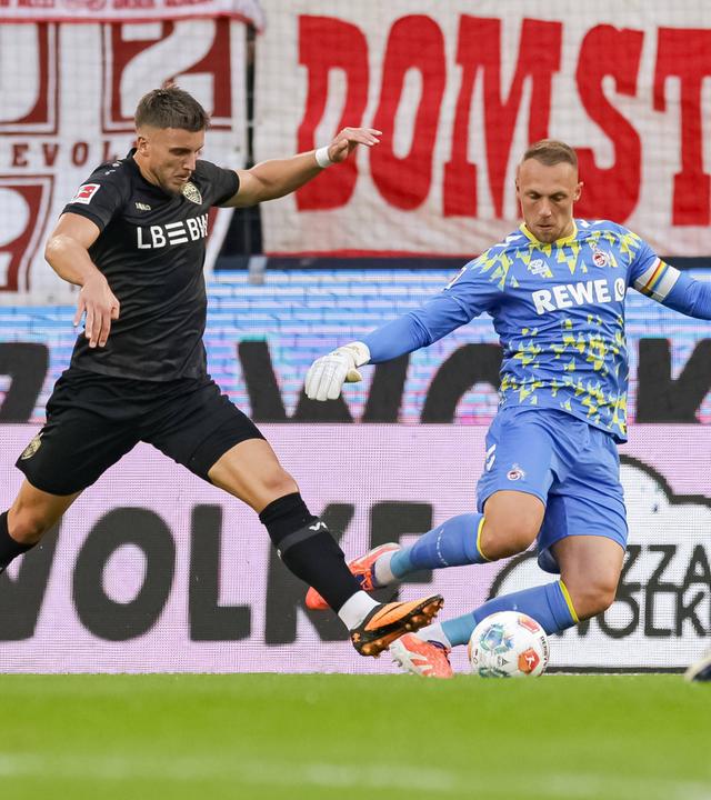 Kölns Torwart Marvin Schwäbe foult Stuttgarts Ermedin Demirovic.