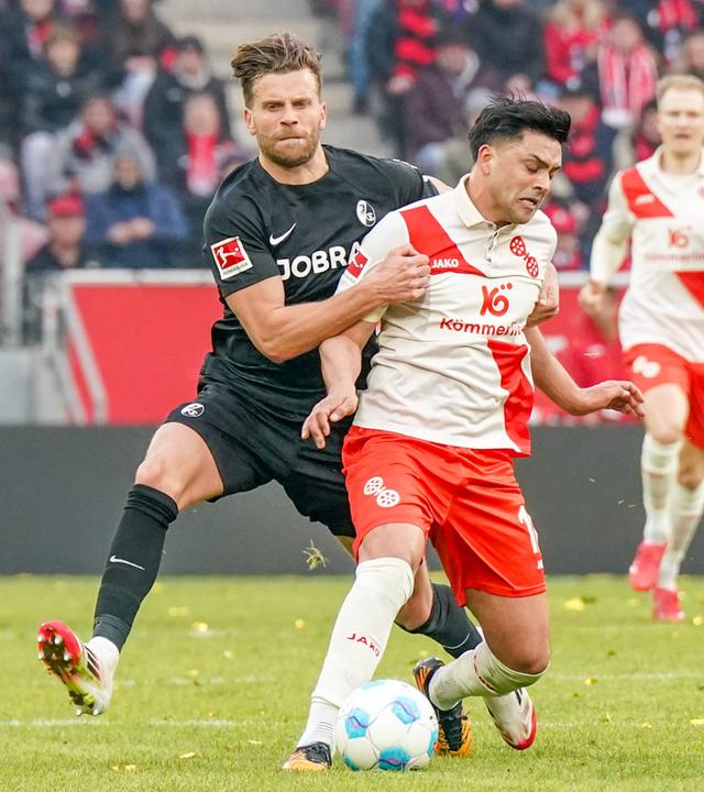 Lucas Höler vom SC Freiburg stoppt den Mainzer Nadiem Amiri taktisch und erhält dafür die Gelbe Karte.