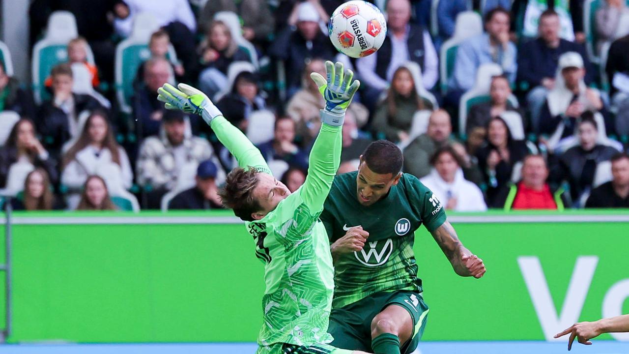 Torhüter Jonas Urbig (FC Bayern München) und Vini Souza (VfL Wolfsburg) kämpfen am 09.05.2026 in der Volkswagen Arena in Wolfsburg um den Ball.