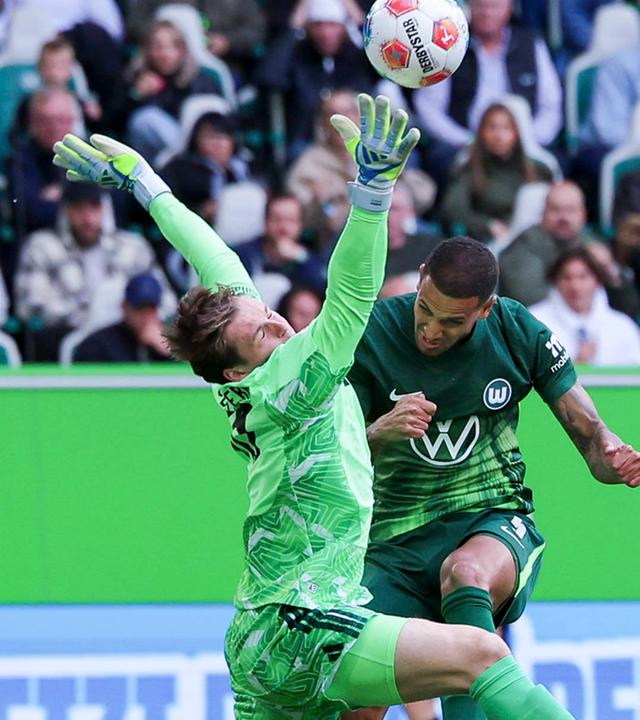 Torhüter Jonas Urbig (FC Bayern München) und Vini Souza (VfL Wolfsburg) kämpfen am 09.05.2026 in der Volkswagen Arena in Wolfsburg um den Ball.