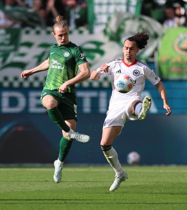Patrick Wimmer (VfL Wolfsburg) und Arthur Theate (Eintracht Frankfurt) kämpfen um den Ball am 11.04.2026 in Wolfsburg.