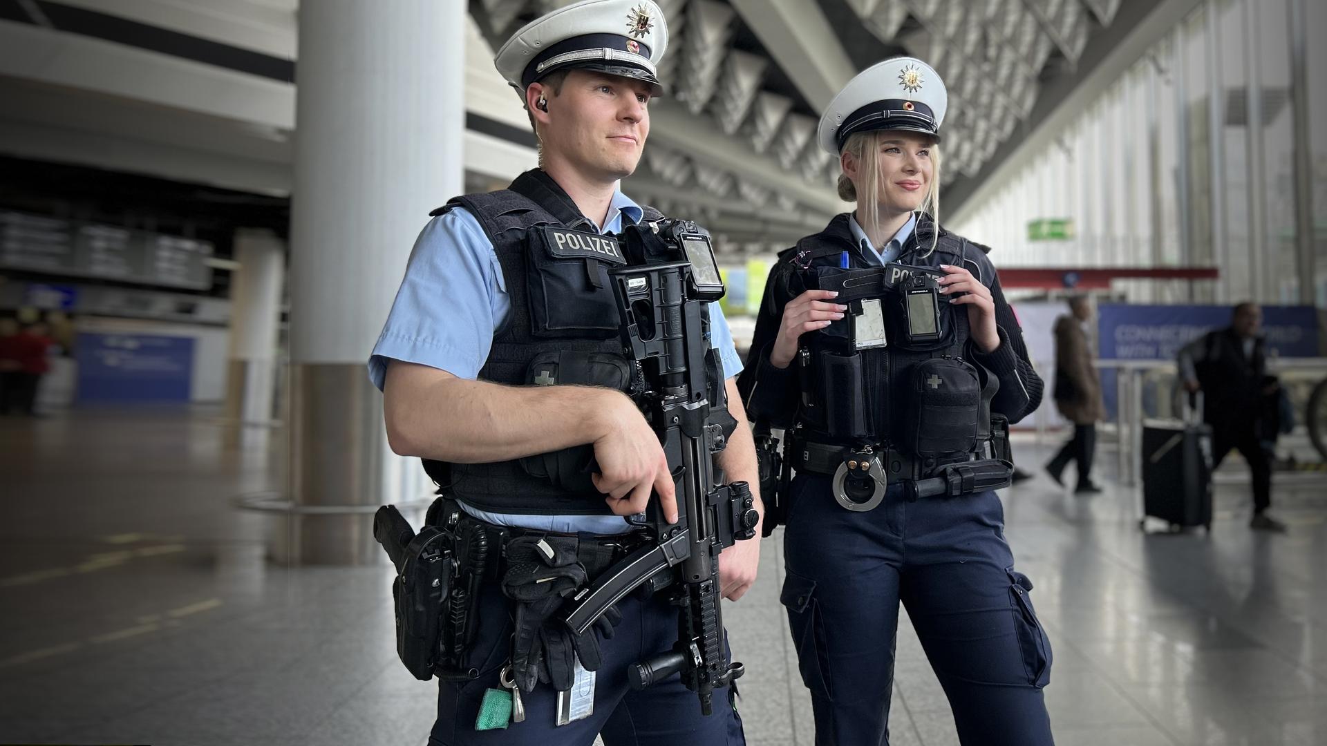 Ein Bundespolizist steht mit Waffe neben seiner Kollegin in der Terminal-Halle vom Frankfurter Flughafen.