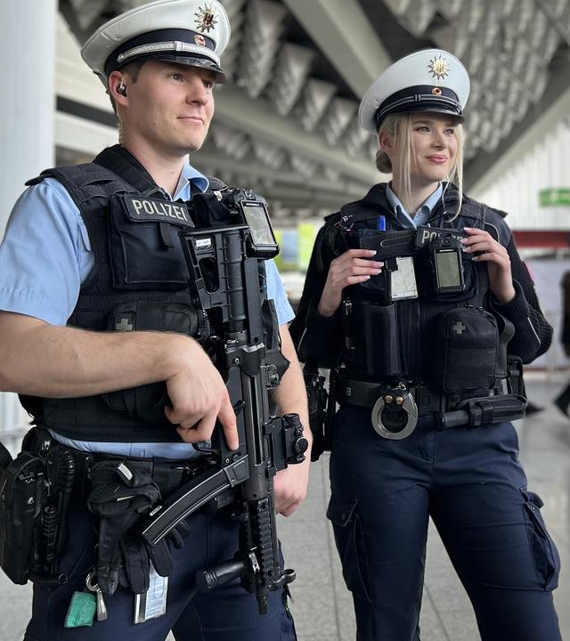 Ein Bundespolizist steht mit Waffe neben seiner Kollegin in der Terminal-Halle vom Frankfurter Flughafen.