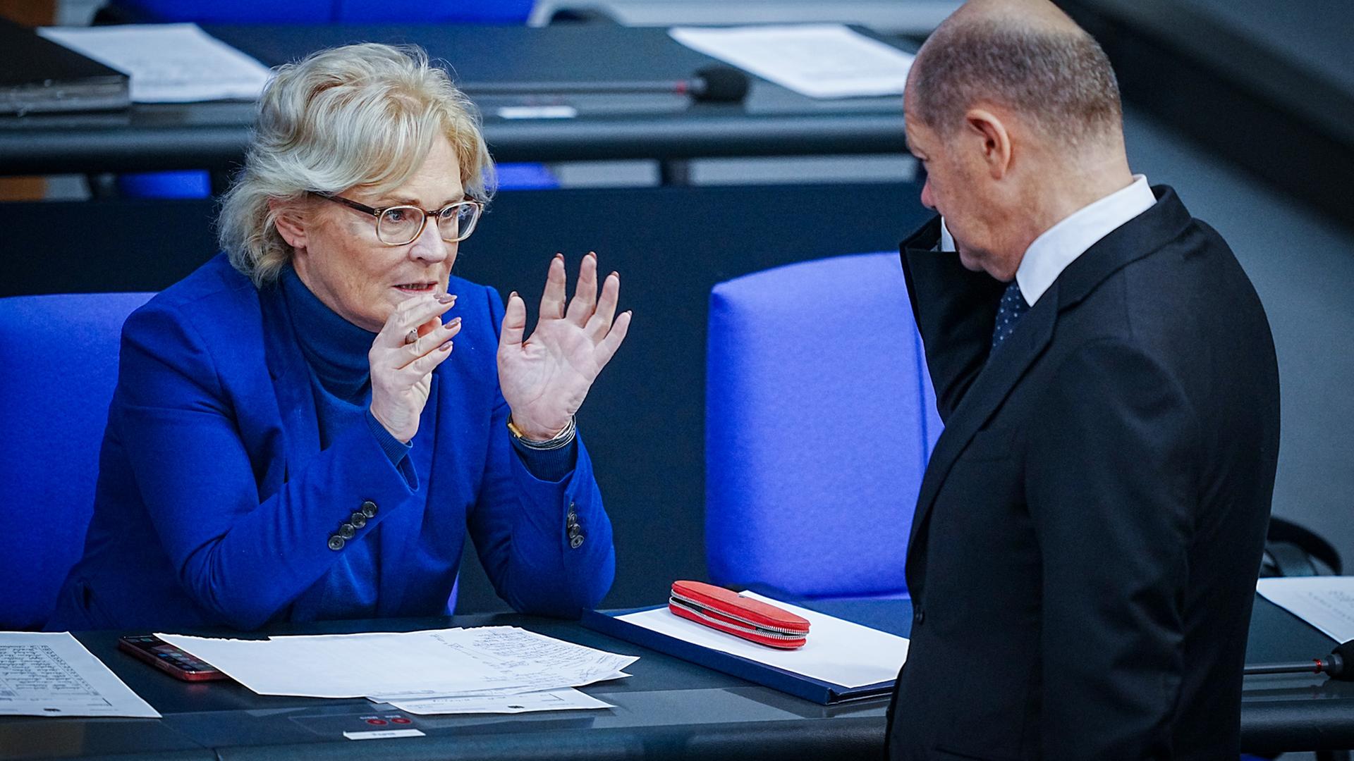 Berlin: Bundeskanzler Olaf Scholz (SPD) und Christine Lambrecht (SPD), Bundesministerin der Verteidigung, unterhalten sich im Bundestag bei der Generaldebatte. 
