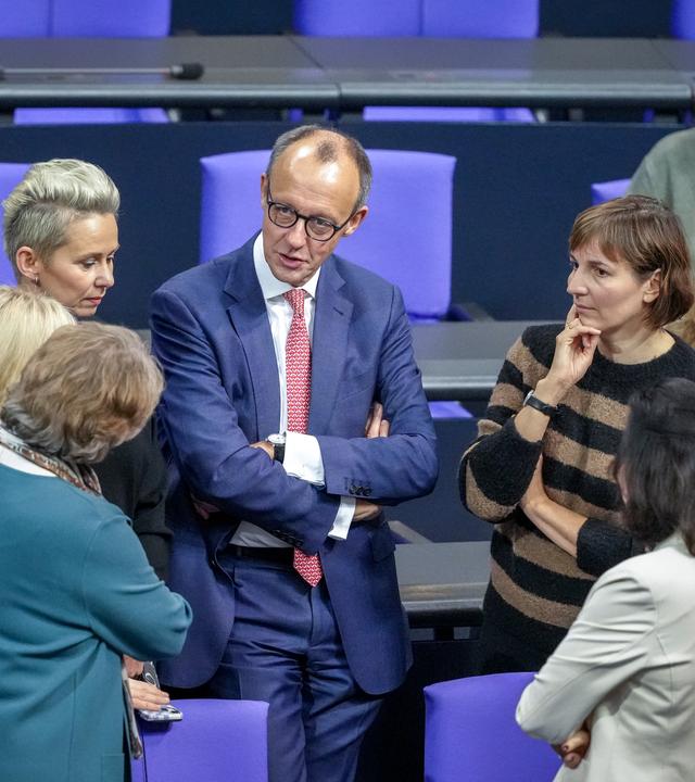  Berlin: Friedrich Merz (CDU, M), CDU-Bundesvorsitzender und Unionsfraktionsvorsitzender, steht im Plenum des Bundestags mit Abgeordneten der Unions-Fraktion zusammen.