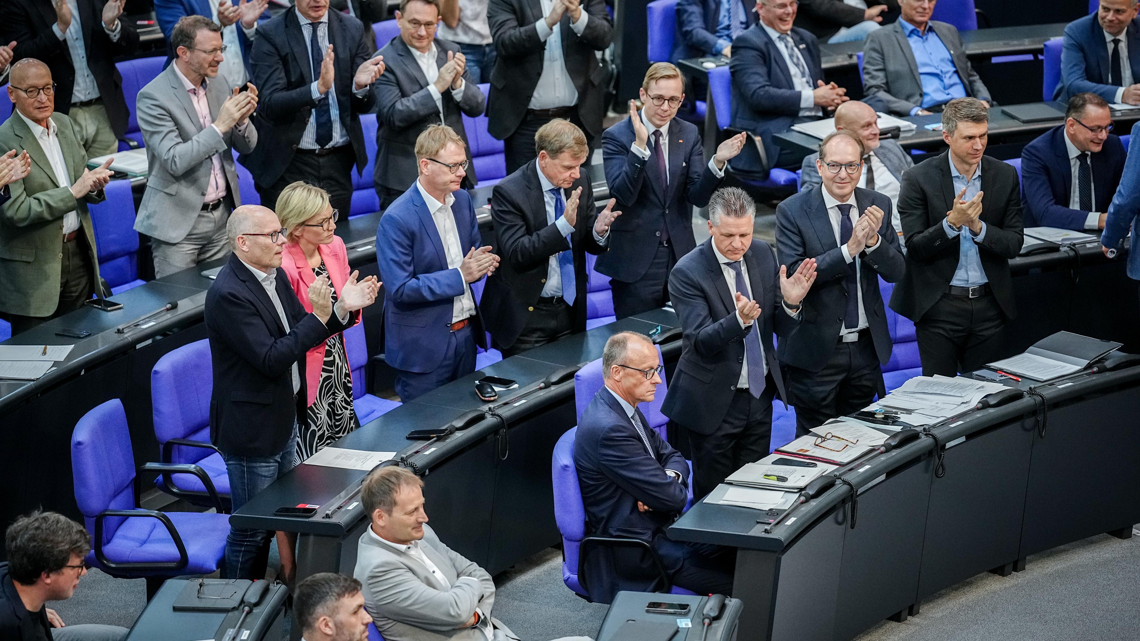 Friedrich Merz (CDU), CDU-Bundesvorsitzender und Unionsfraktionsvorsitzender, nimmt bei der Sitzung des Bundestags den Applaus seiner Fraktion entgegen.