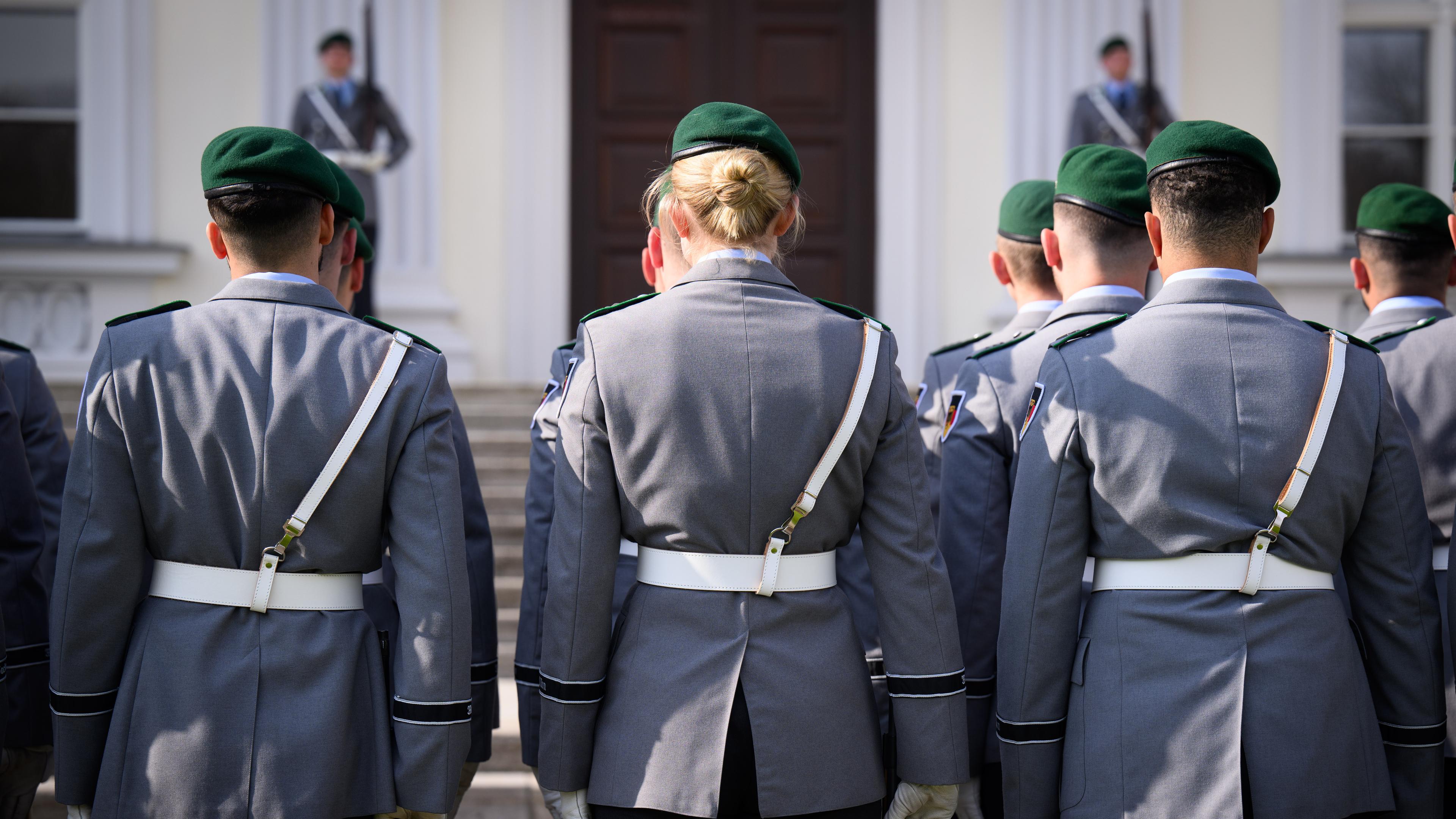 Eine Soldatin und zahlreiche Soldaten der Ehrenformation der Bundeswehr stehen anlässlich der Akkreditierung von Botschaftern durch Bundespräsident Steinmeier vorm Schloss Bellevue.
