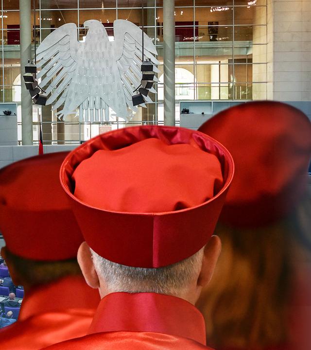 Drei Richter vor einem Symbolbild des Bundestages