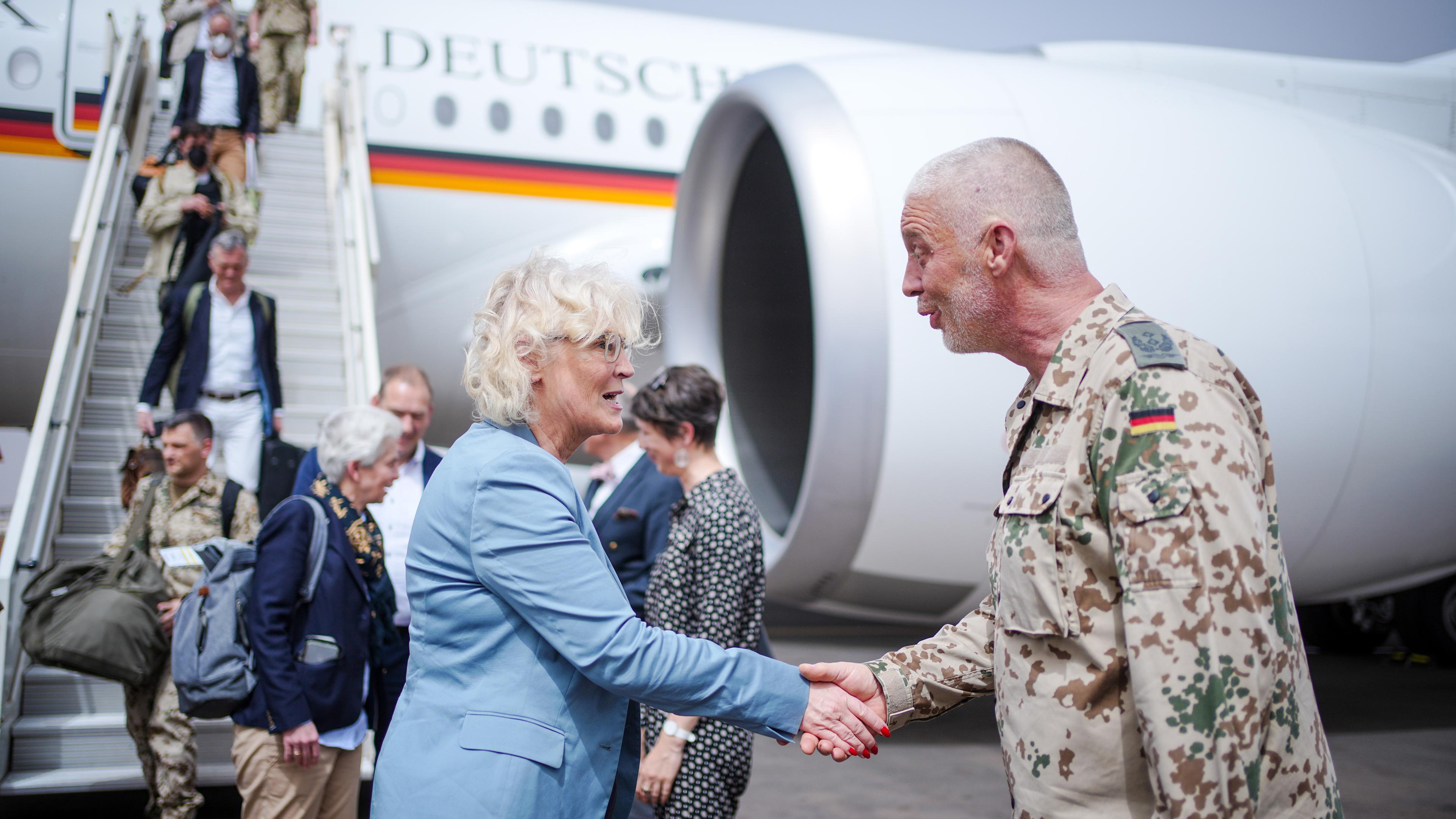 Bundesverteidigungsministerin Christine Lambrecht schütelt die Hand eines Bundeswehr-Soldaten. Sie stehen vor einem Flugzeug. Mali.