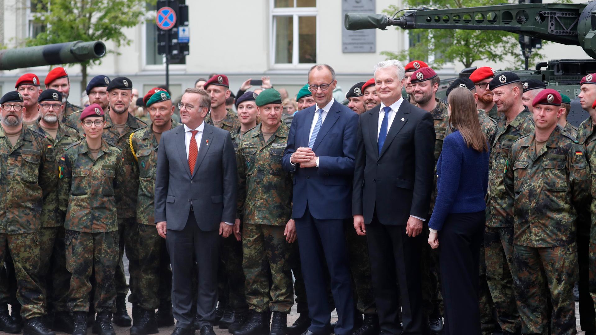 German Defence Minister Boris Pistorius, German Chancellor Friedrich Merz, Lithuanian President Gitanas Nauseda and Lithuanian Defence Minister Dovile Sakaliene pose for a group photograph with German servicemen and servicewomen after the inauguration of the German 45th Armoured Brigade 'Lithuania', at the Cathedral Square in Vilnius