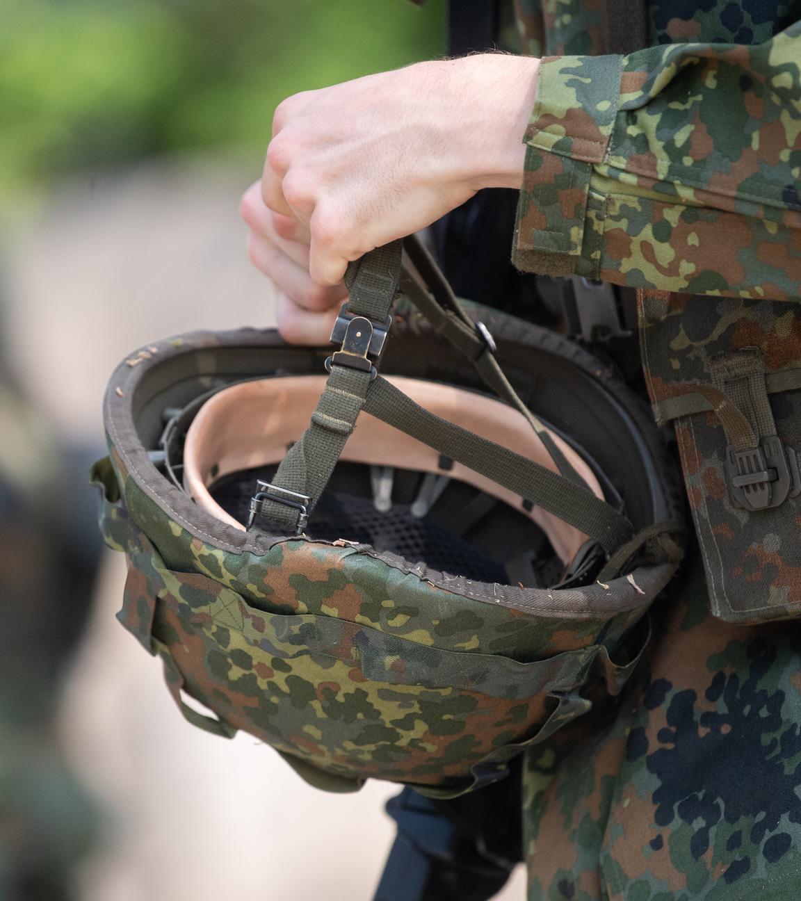 Ein Reservist in Ausbildung hält während eines Ausbildungsmoduls des Projektes "Ungediente für die Reserve" des Landeskommandos Hessen auf dem Truppenübungsplatz Hammelburg seinen Helm in der Hand.