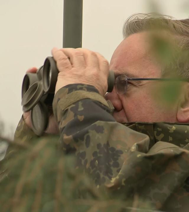 Verteidigungsminister Boris Pistorius sieht durch ein Fernrohr