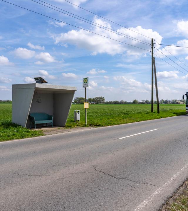 Bushaltestelle auf dem Land mit ankommendem Bus