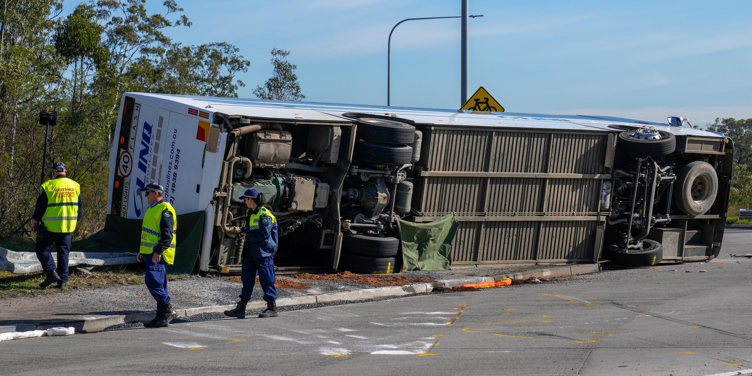 Die Polizei inspiziert einen Bus, der in der im Hunter Valley nördlich von Sydney, auf die Seite kippte.