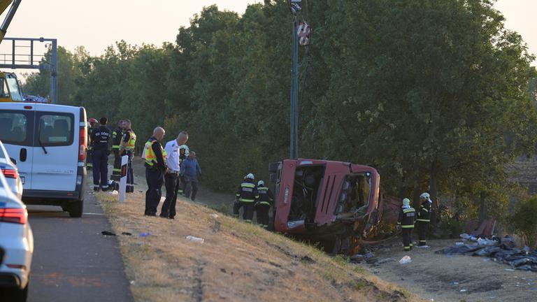 Rettungskräfte sind vor Ort, nachdem ein Personenbus von der Straße abgekommen und in einen Graben gestürzt war.