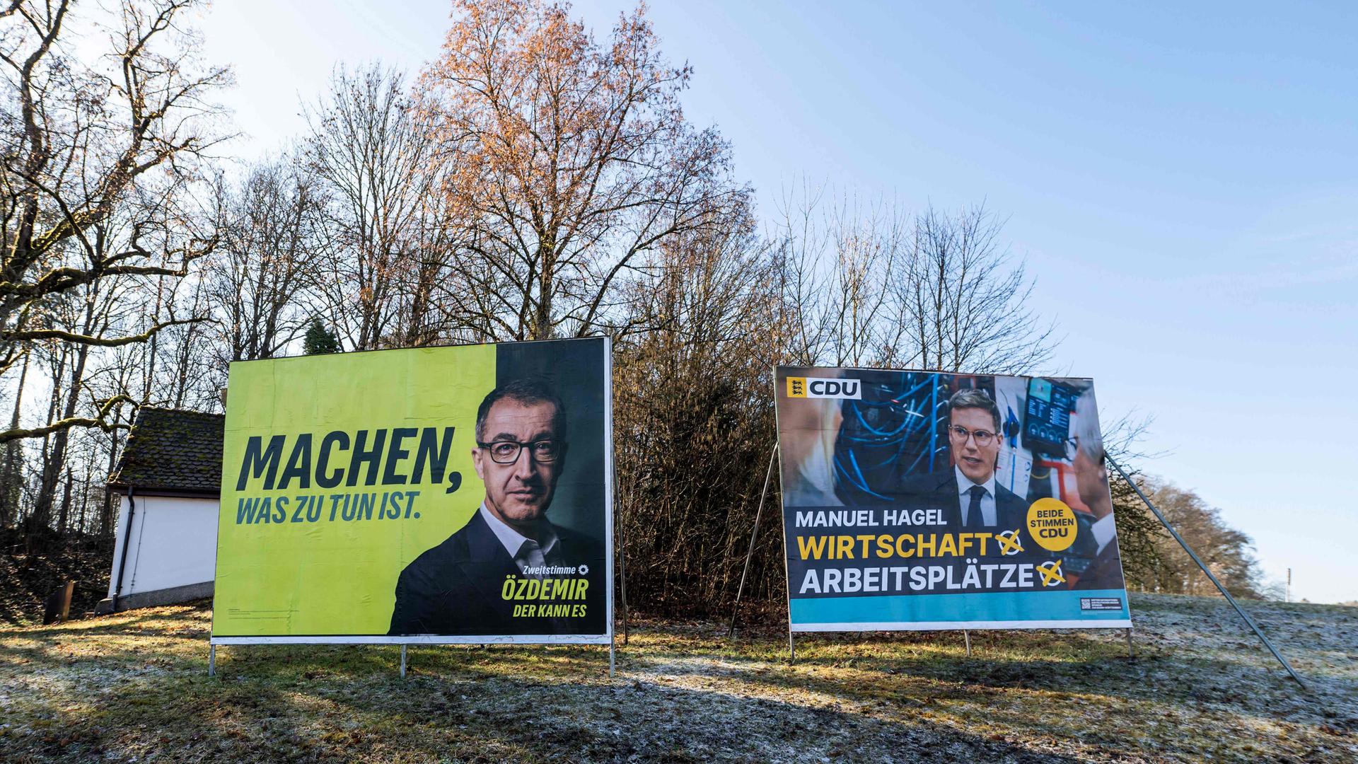 Wahlplakate der Grünen mit Spitzenkandidat Cem Özdemir neben CDU-Plakaten mit Manuel Hagel an einer Straße in Villingen-Schwenningen vor der Landtagswahl in Baden-Württemberg.