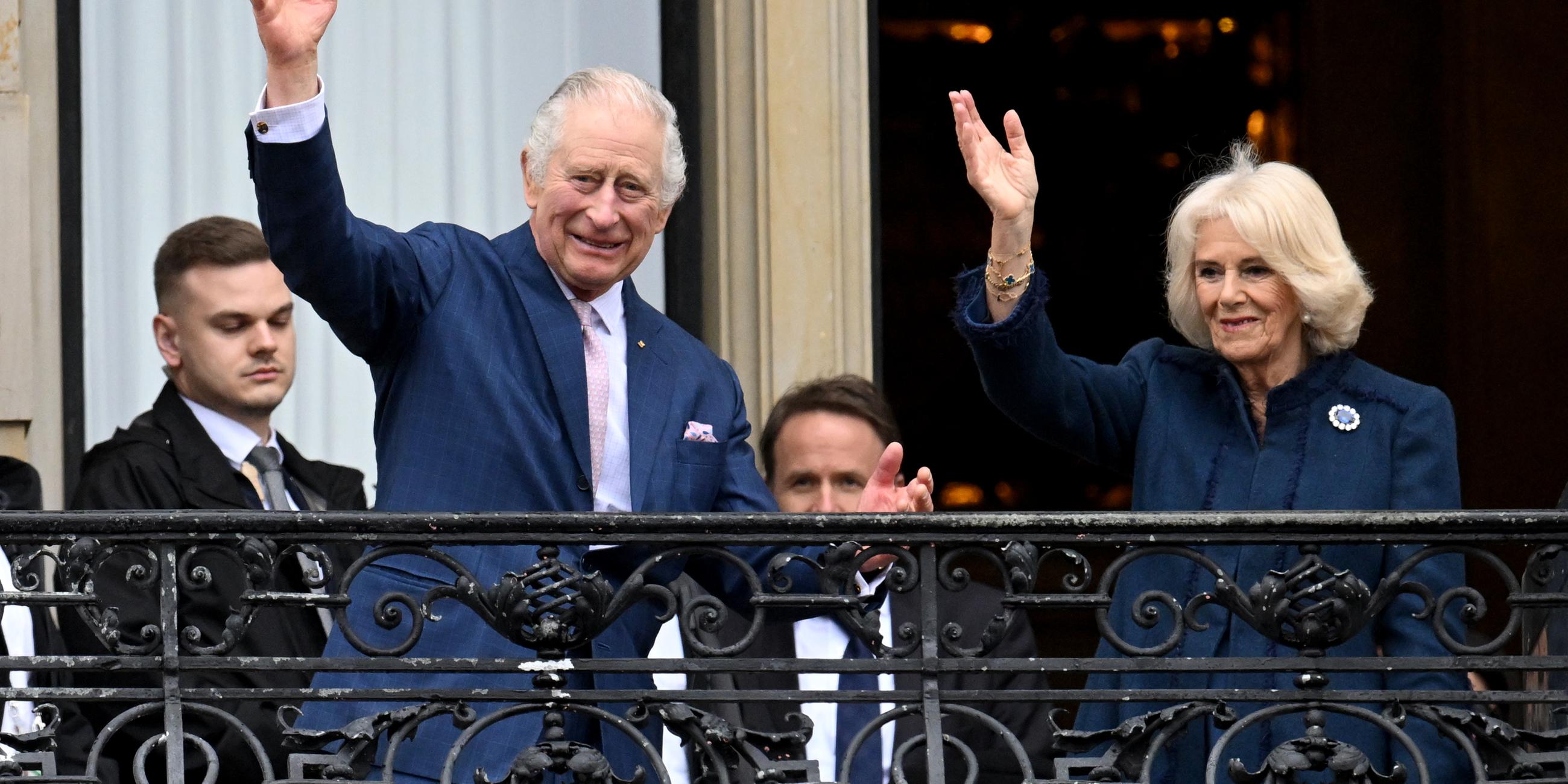 König Charles III. von Großbritannien und Königsgemahlin Camilla winken vom Balkon des Hamburger Rathauses.