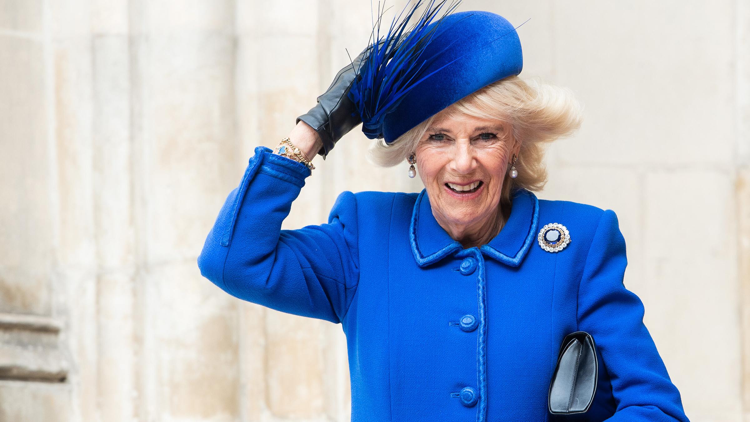 Königin Camilla hält ihren Hut fest