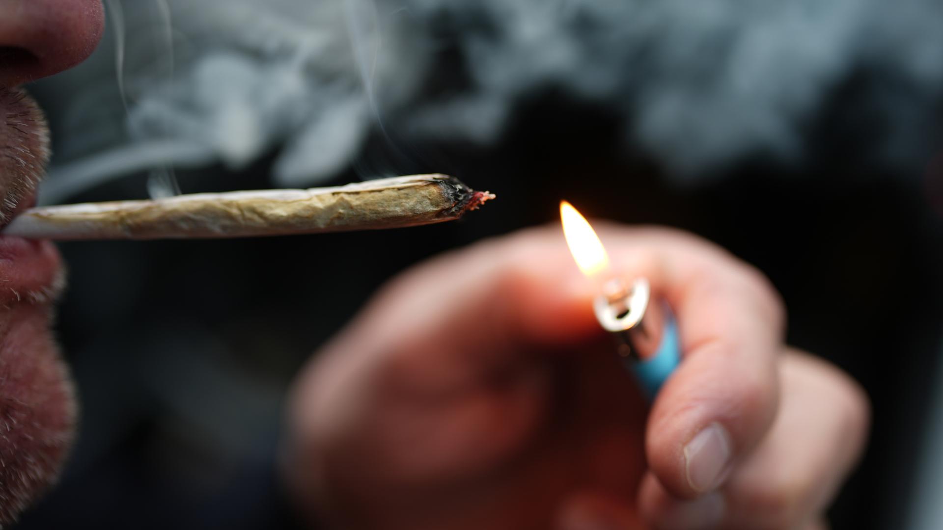 Mann zündet sich Cannabis-Zigarette an