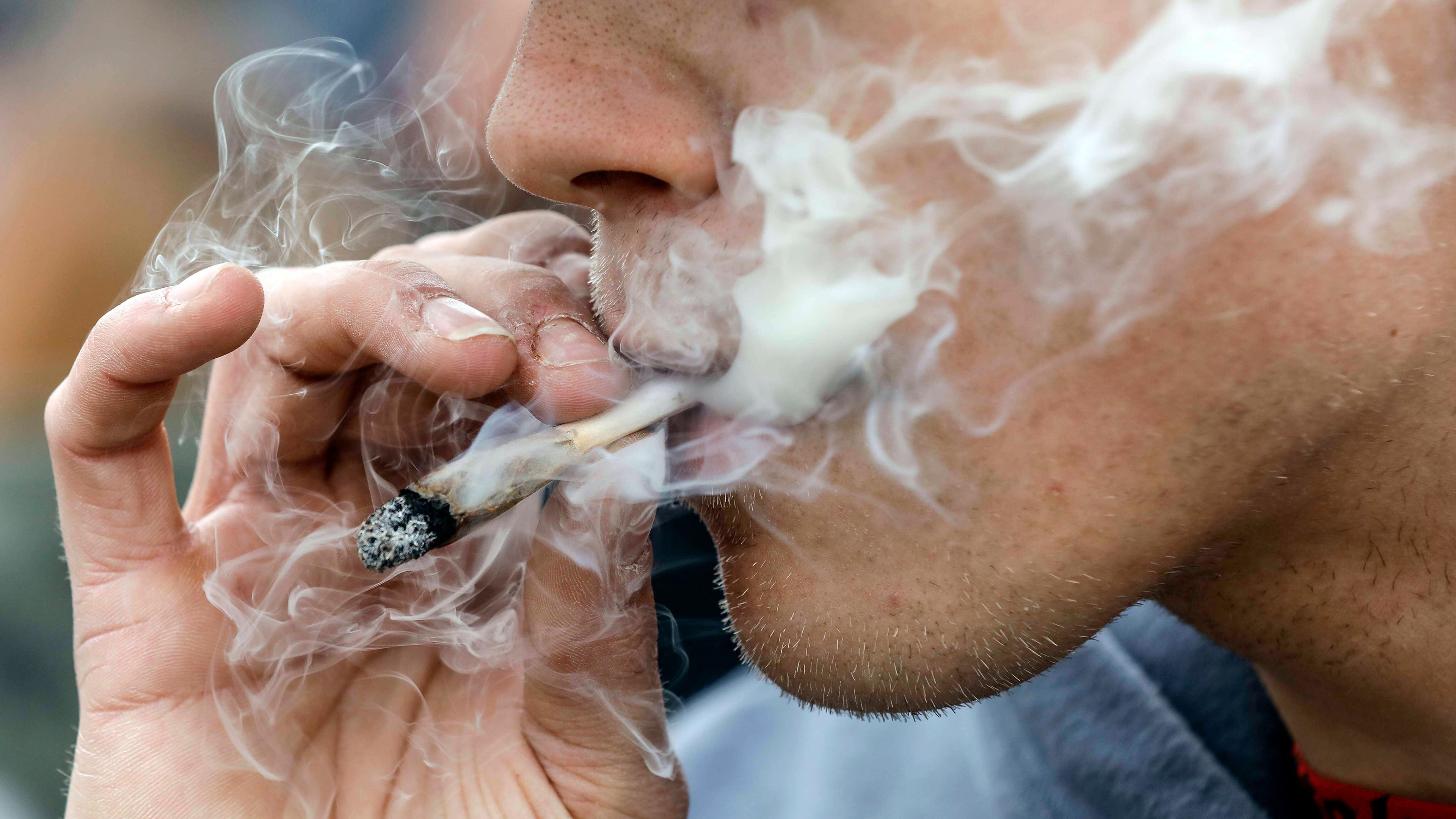 Archiv: Eine Mann raucht einen Joint während einer Demonstration