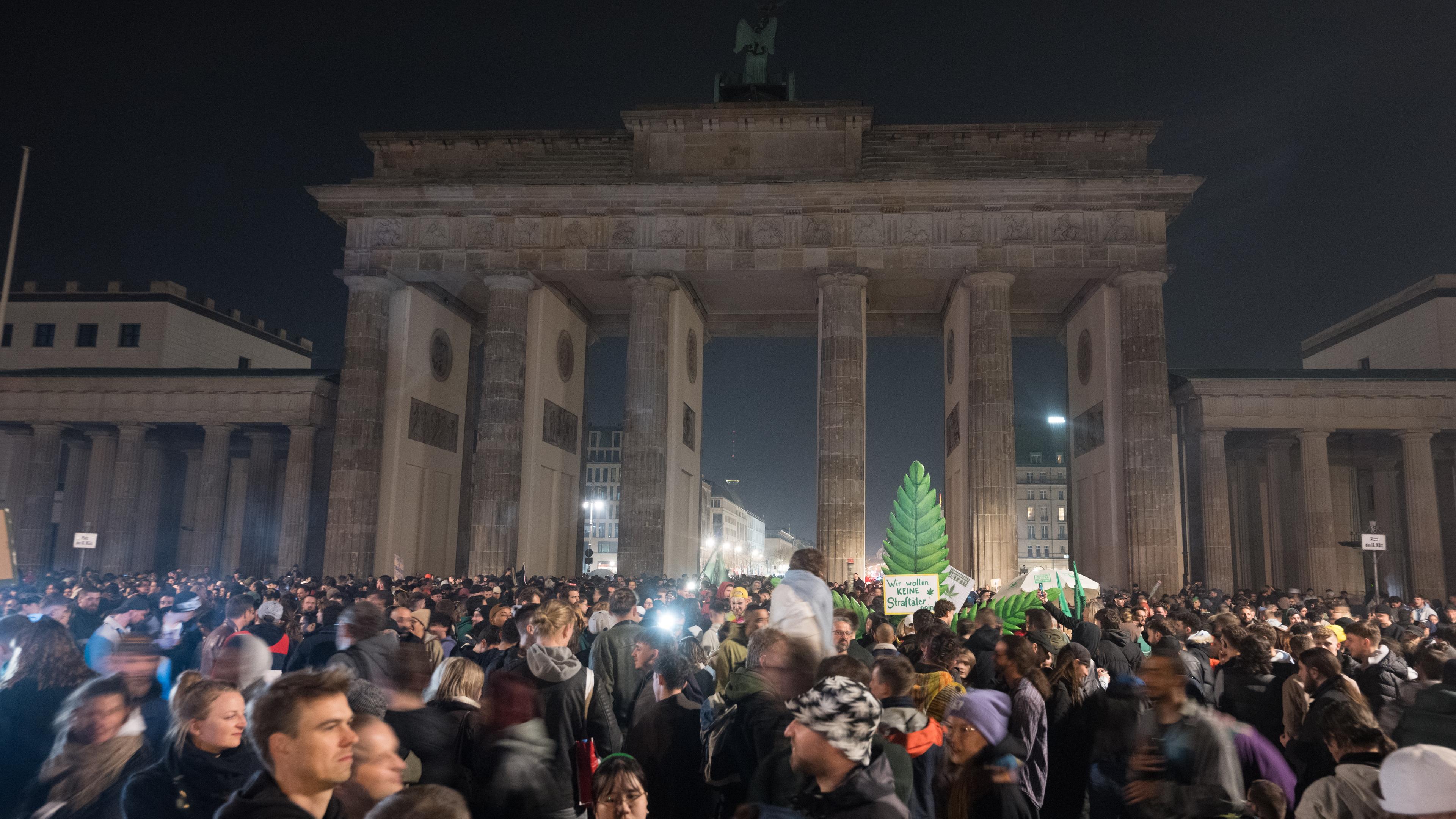 01.04.2024, Berlin: Teilnehmer rauchen während eines "Smoke In" vor dem Brandenburger Tor Cannabis.