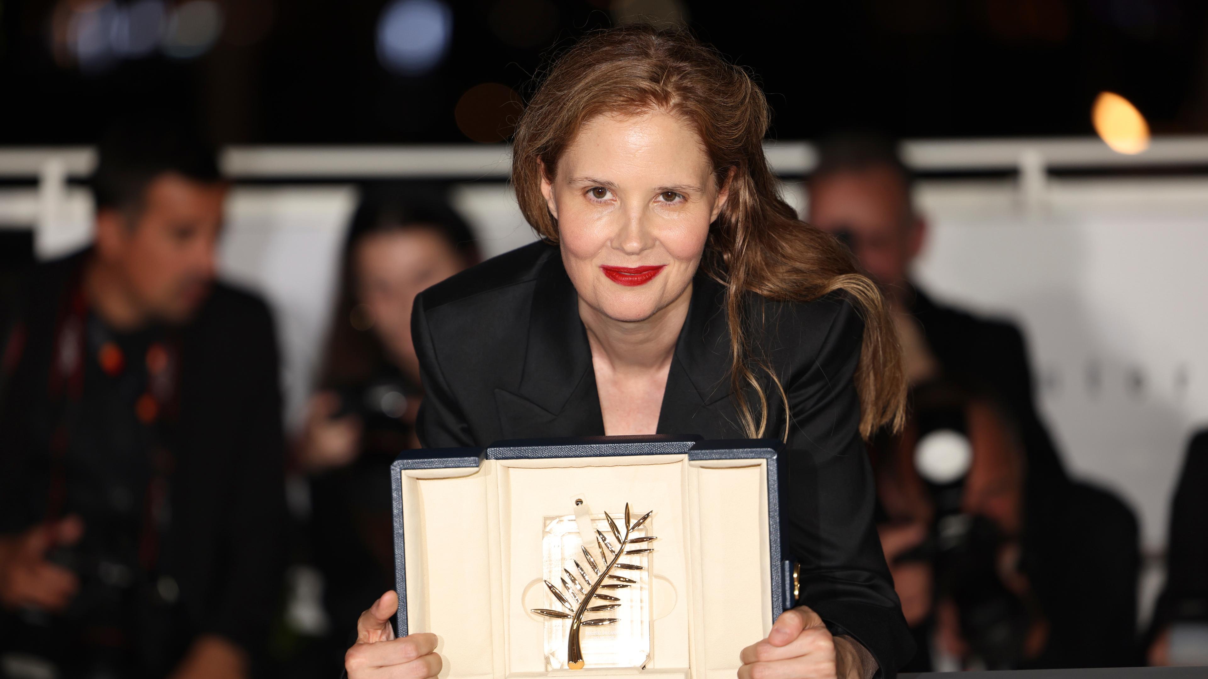 Zu sehen ist die französische Regisseurin Justine Triet mit der ihr verliehenen Goldenen Palme beim Fimfestival in Cannes.