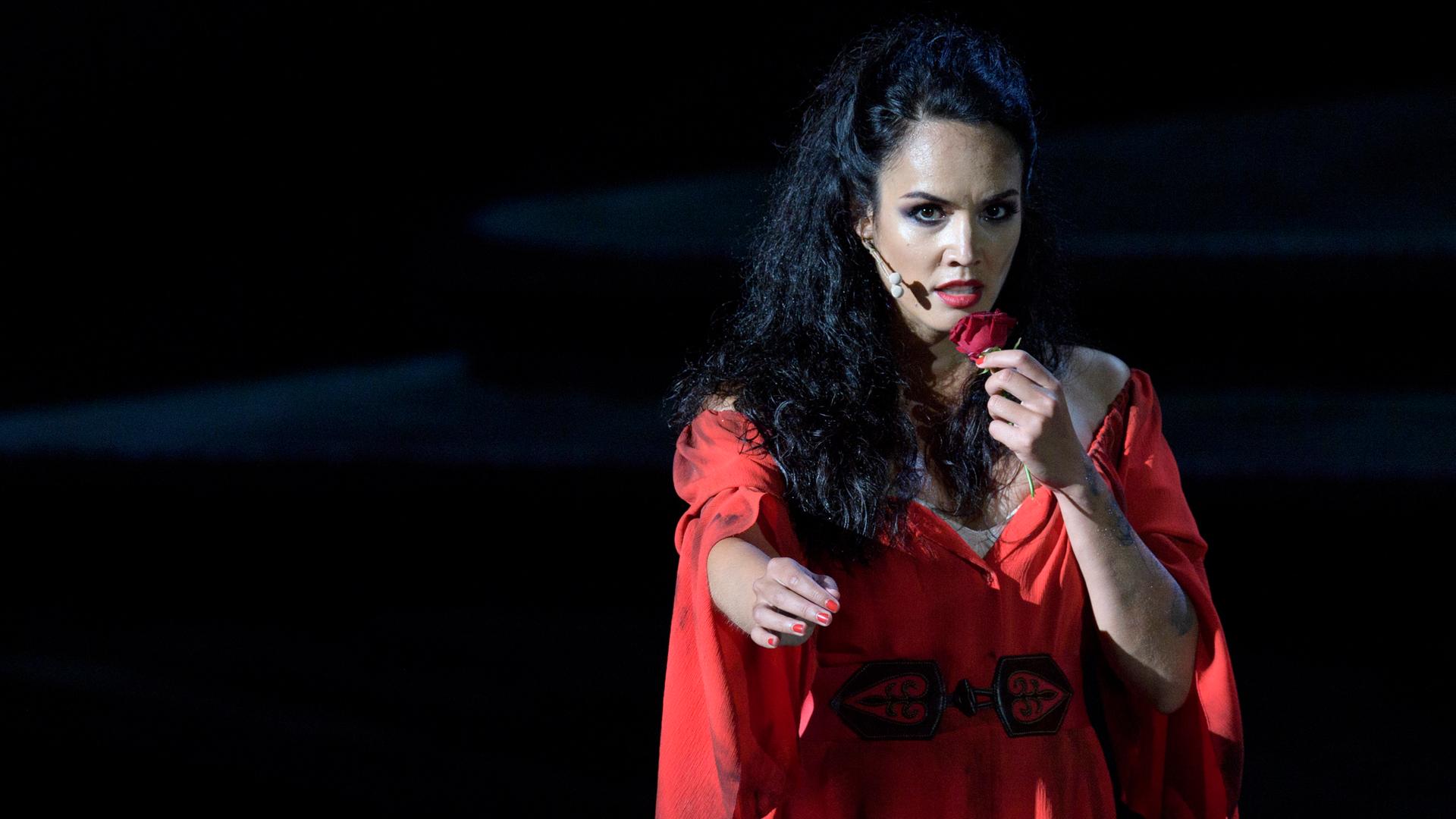 Carmen Gaëlle Arquez im roten Kleid mit einer roten Rose in der linken Hand.