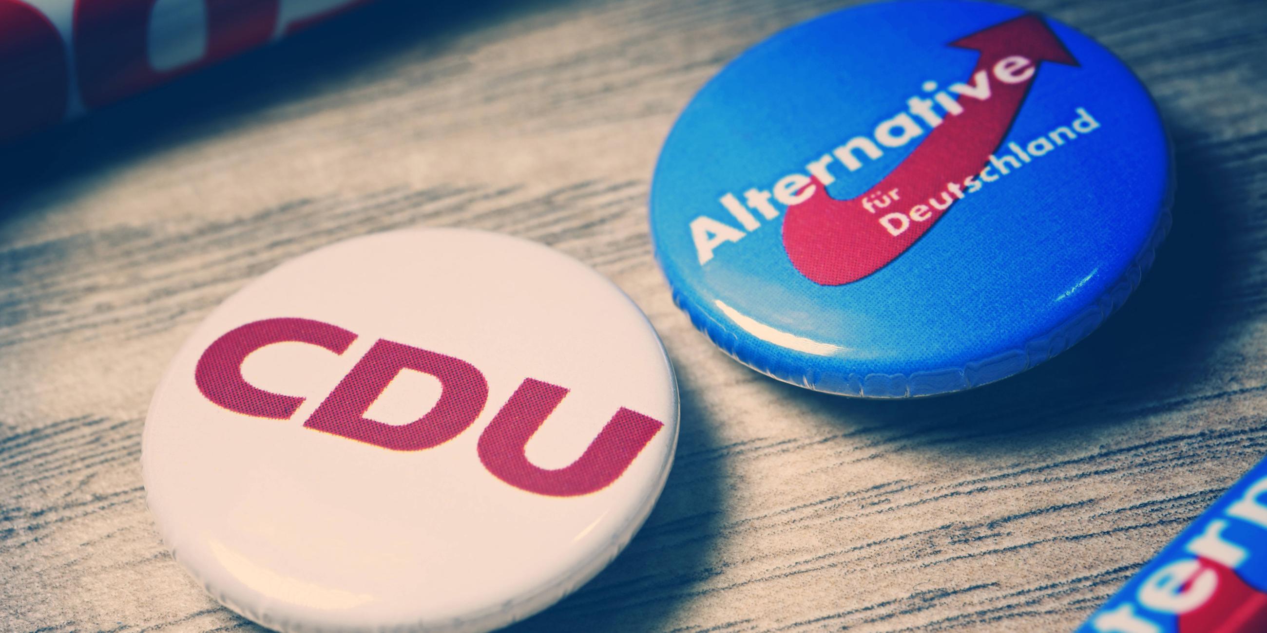Partei-Anstecker mit Logos von CDU und AfD