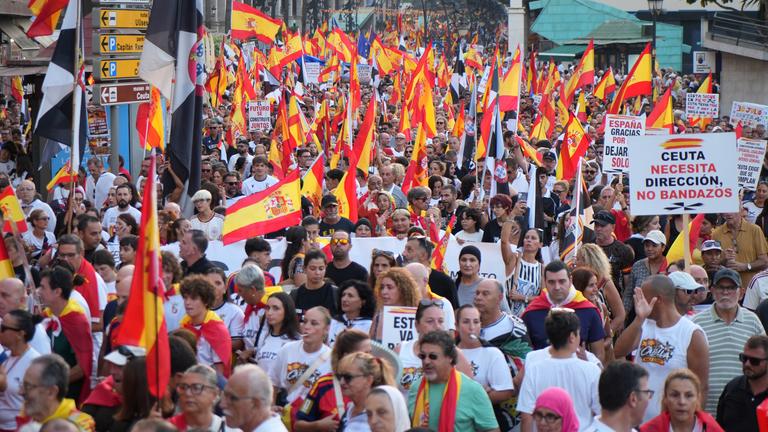Menschen demonstrieren mit Schildern in der spanischen Eklave Ceuta.