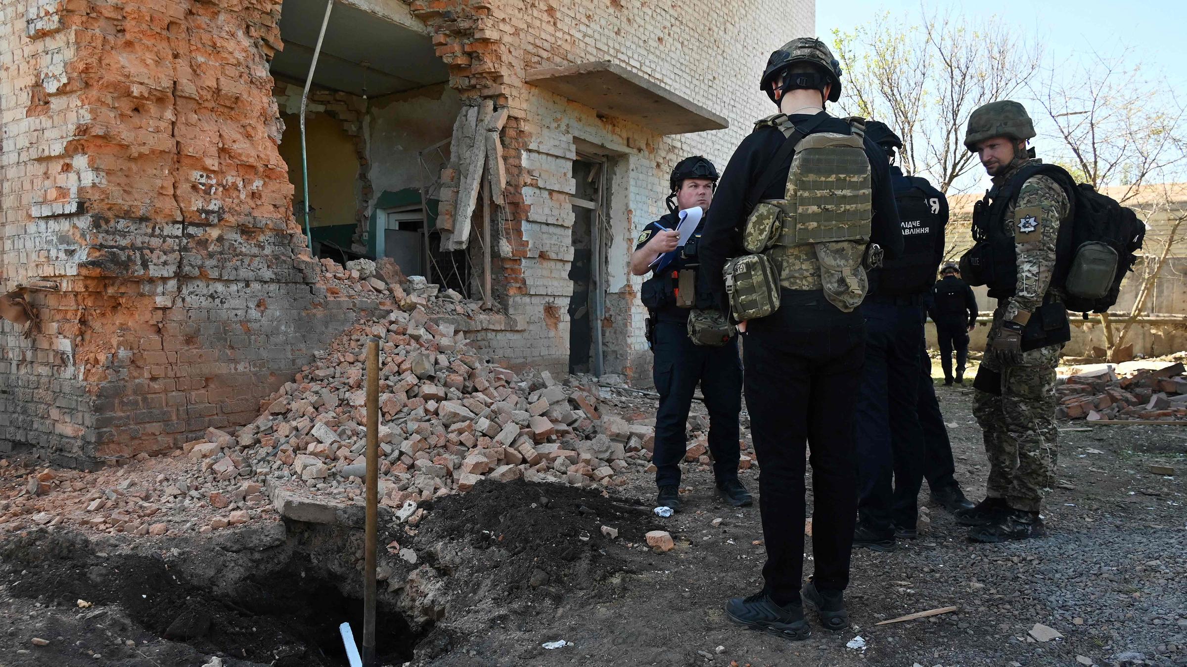 Polizeibeamte arbeiten am Ort eines Raketenangriffs in Charkiw.