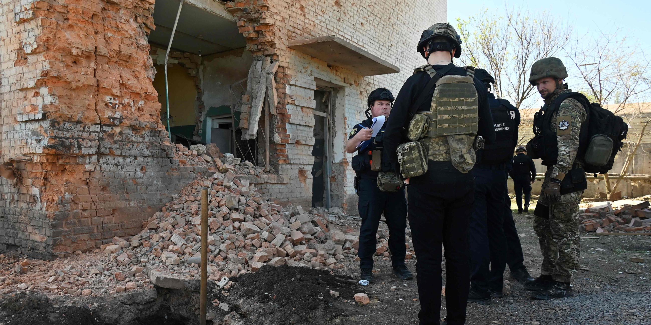 Polizeibeamte arbeiten am Ort eines Raketenangriffs in Charkiw.