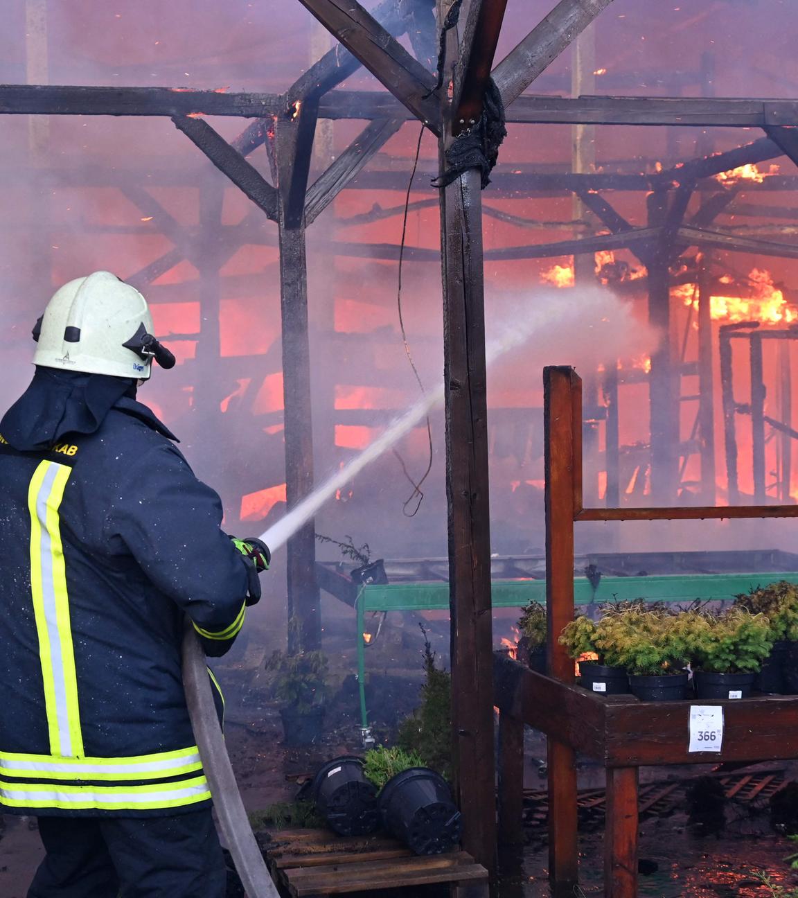 Ein ukrainischer Feuerwehrmann löscht in Charkiw einen Brand in einem Baumarkt nach einem russischen Angriff.