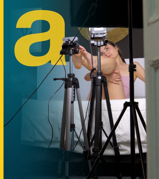 Eine Frau auf dem Bett vor den Kameras.