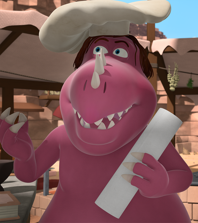 Chef steht grinsend in seiner Küche und hält ein Stück Papier in der Hand. Hinter ihm steht Trutbert.