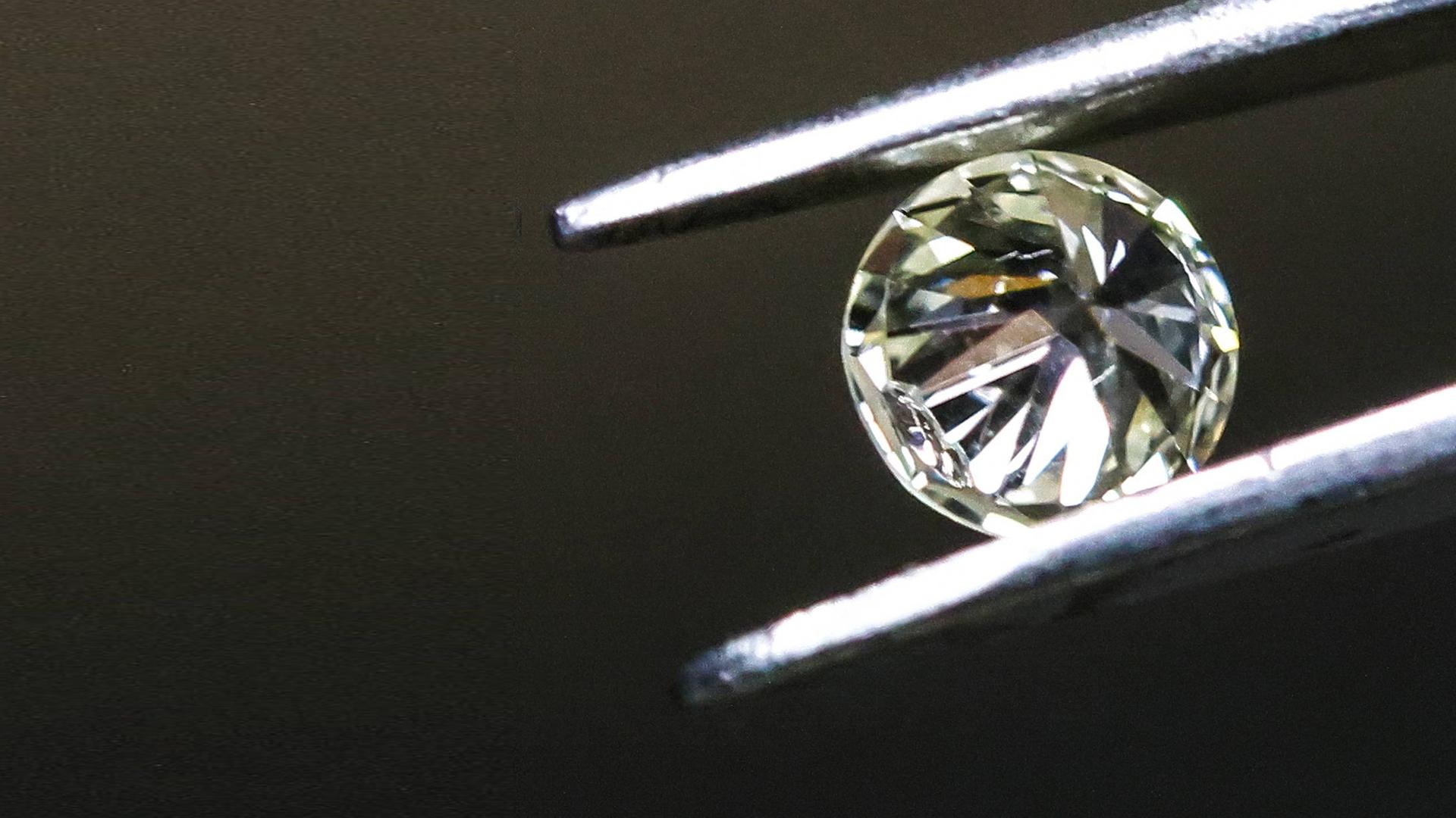 Ein Diamant, von einer Pinzette gehalten