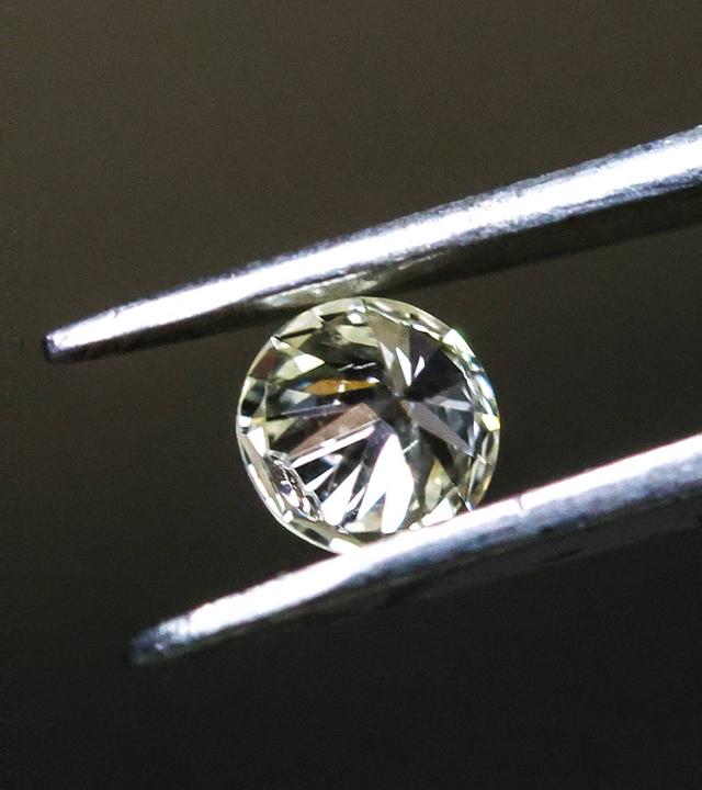 Ein Diamant, von einer Pinzette gehalten