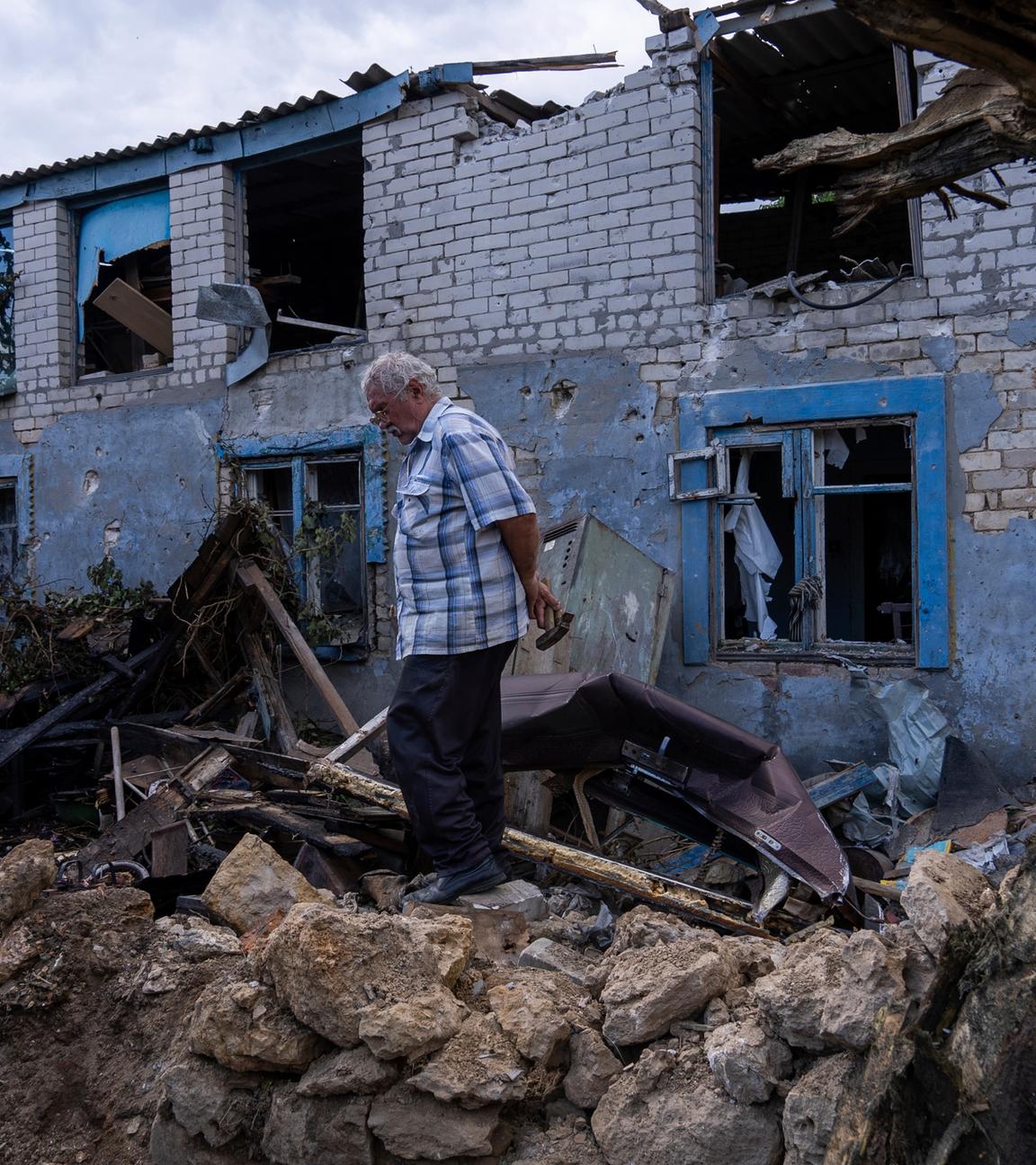 Ein Einheimischer geht vor einem durch russischen Beschuss beschädigten Gebäude in Cherson.