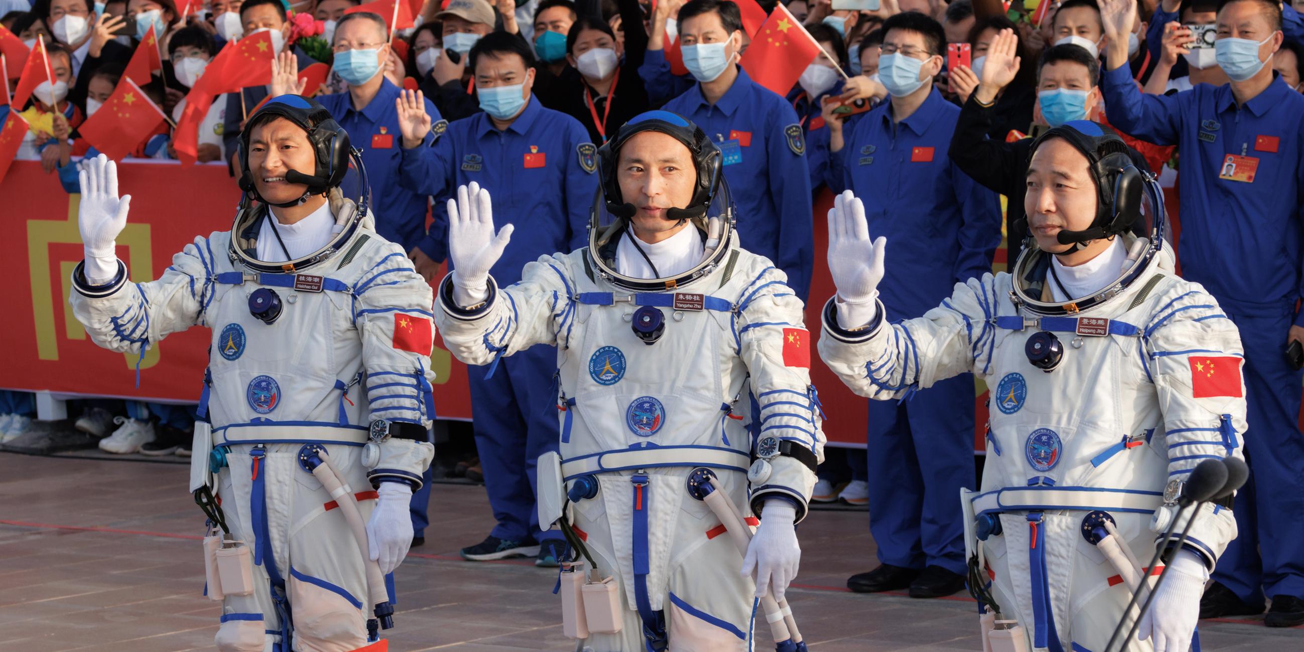 Die drei Astronauten winken während der Abschiedszeremonie, bevor sie zum Start der Raumflugmission Shenzhou-16 aufbrechen.