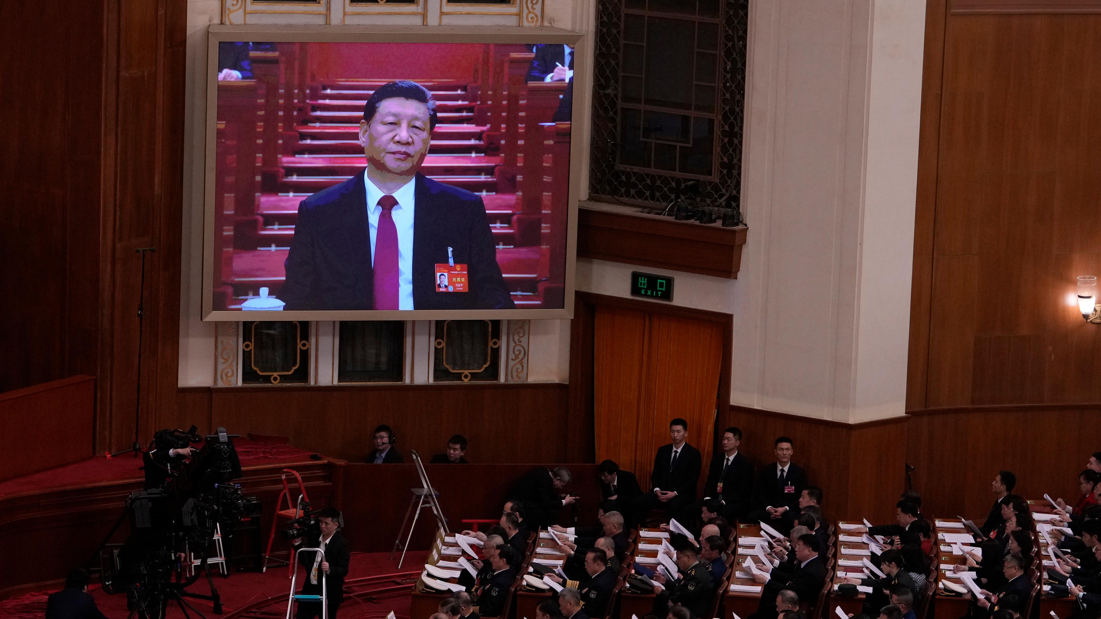 Xi Jinping, Präsident von China, (auf dem Bildschirm) hört der Eröffnungsrede von Li, Ministerpräsident von China, während der Eröffnungssitzung des Nationalen Volkskongresses (NVK) in der Großen Halle des Volkes in Peking, China, zu. 