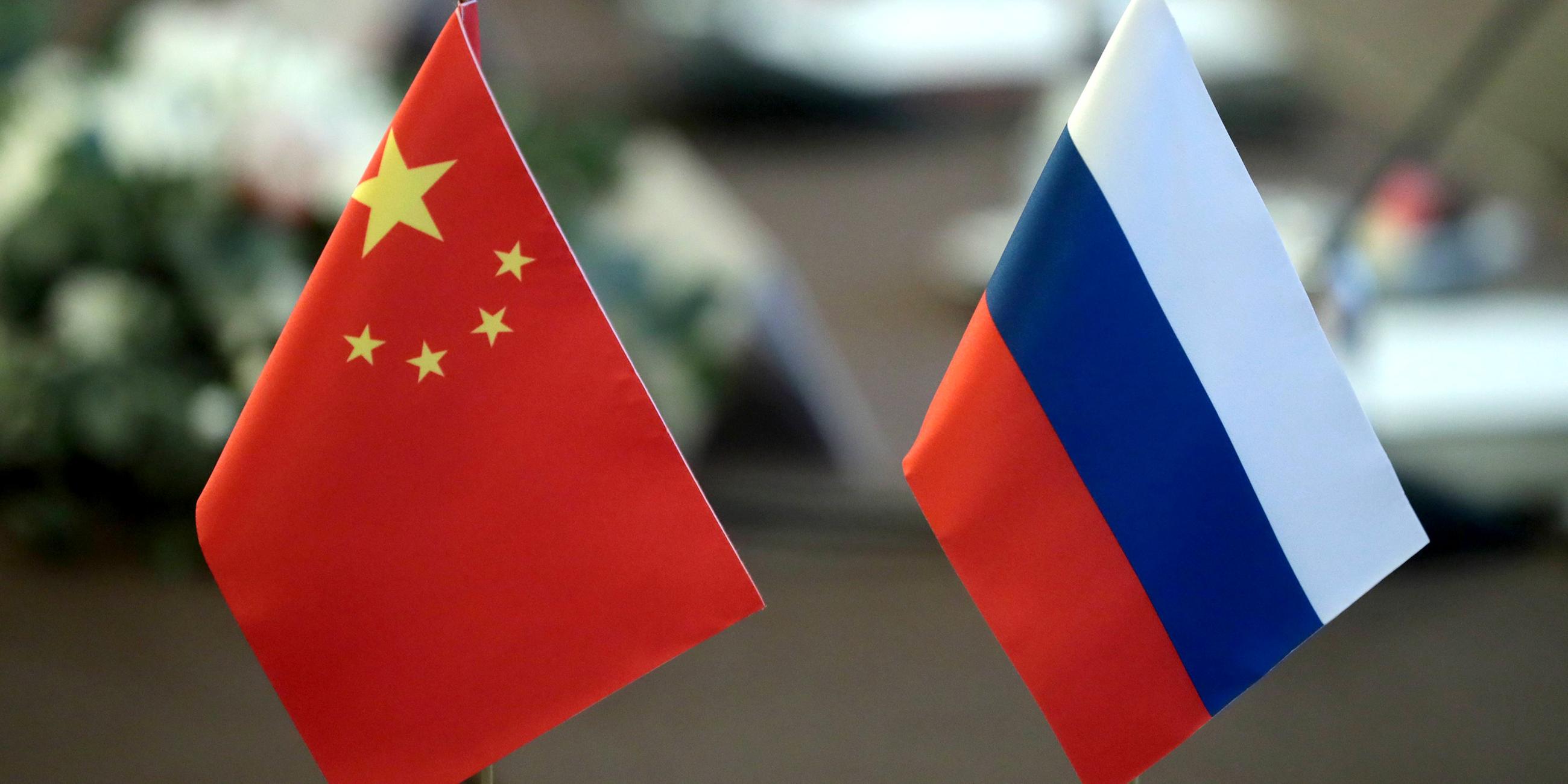 Ein chinesisches und ein russisches Fähnchen stehen nebeneinander.