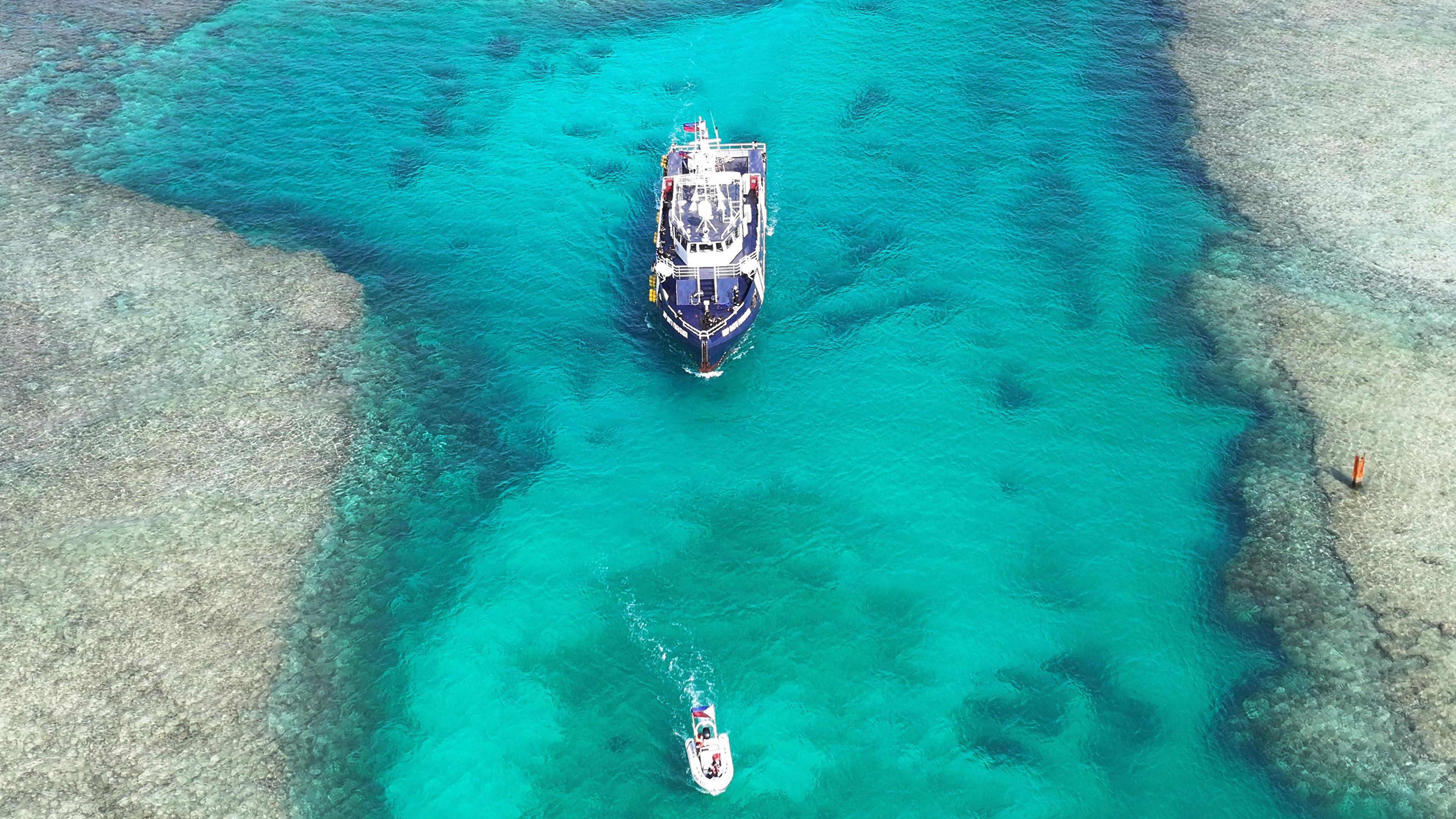 Zwei Schiffe auf türkisfarbenem Wasser.