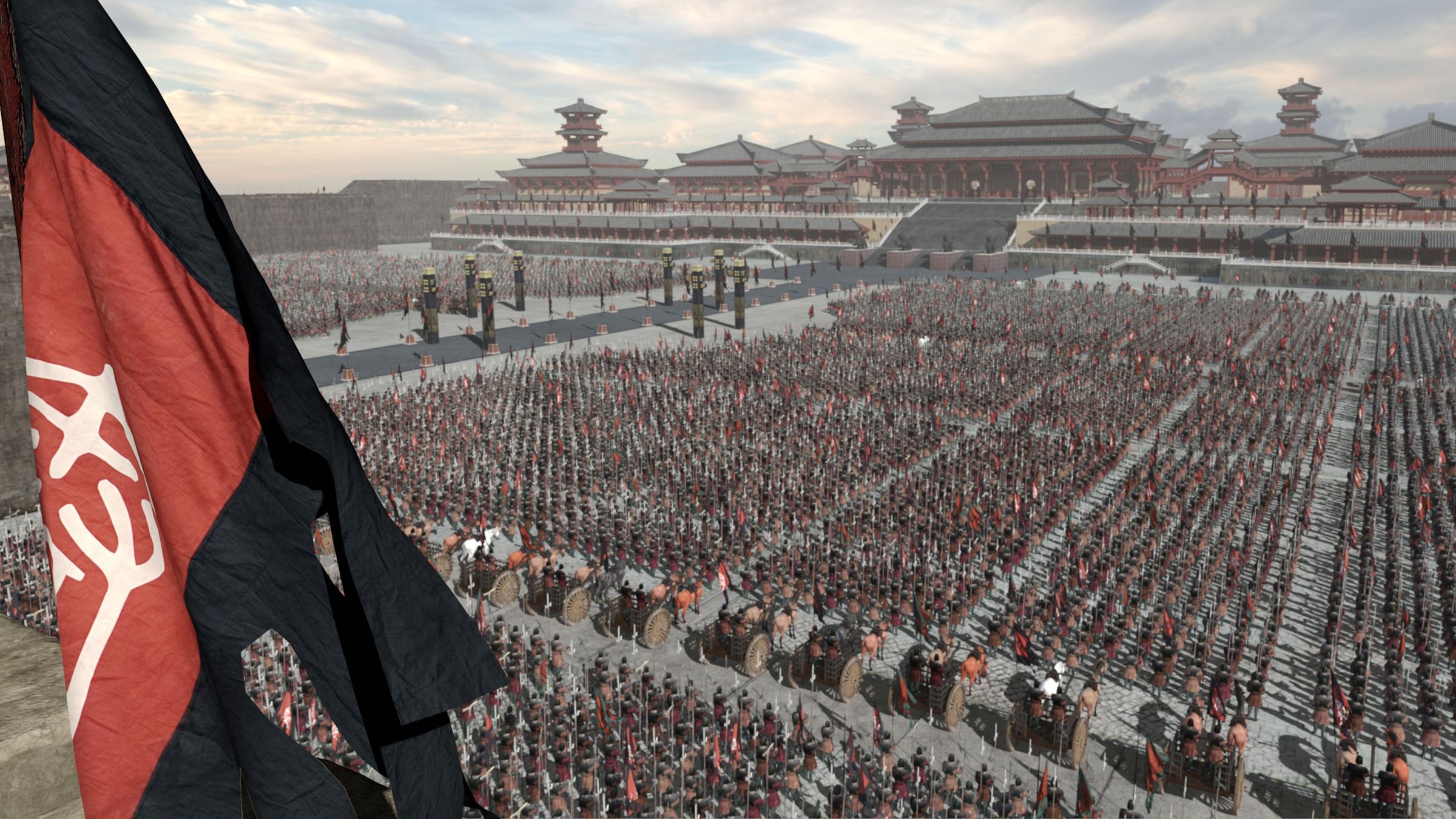  CGI. Tausende von Soldaten in alt-chinesischer Rüstung sind in Rechtecken auf dem schier endlosen Innenhof einer Palast-Anlage angetreten. Zwischen ihnen, im Vordergrund, eine Reihe von Streitwagen. Sie alle sind auf eine Reihe von Pagoden ausgerichtet, die weit hinten unter einem wolkigen Himmel das Bild begrenzen. Von der mittleren Pagode führt eine große Freitreppe auf eine von Säulen gesäumte Prachtstraße. Links im Vordergrund weht die schwarz-rote Standarte des Qin-Reichs.