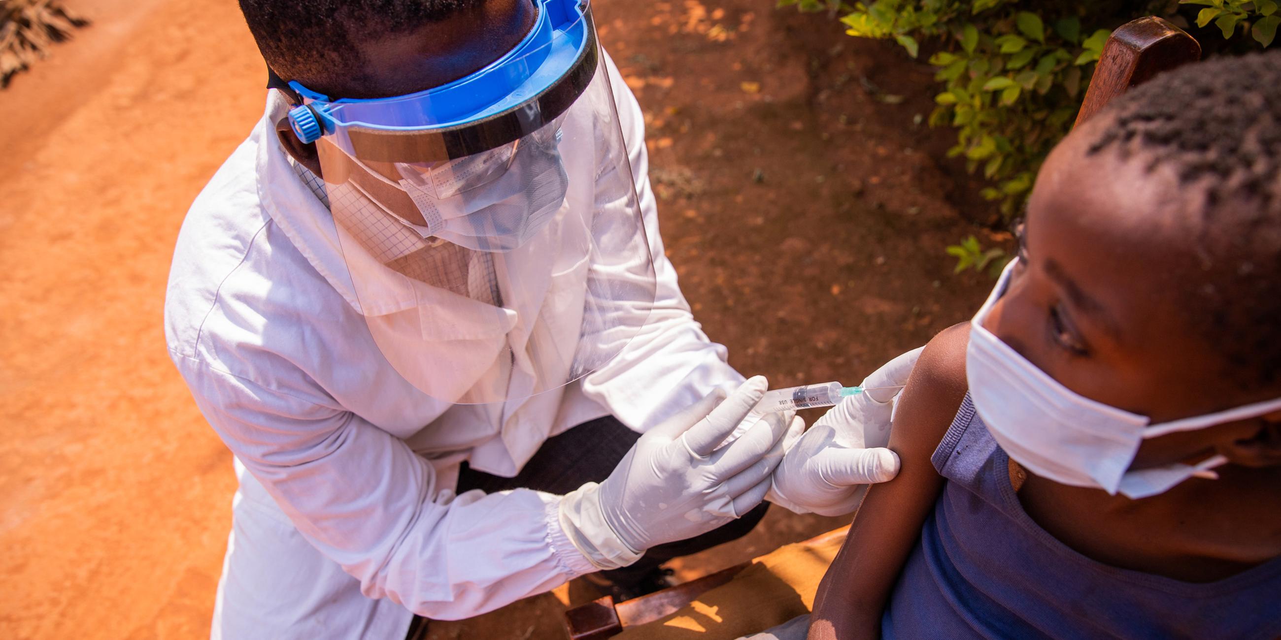 Ein Arzt impft ein Kind in Afrika während eines Arztbesuchs