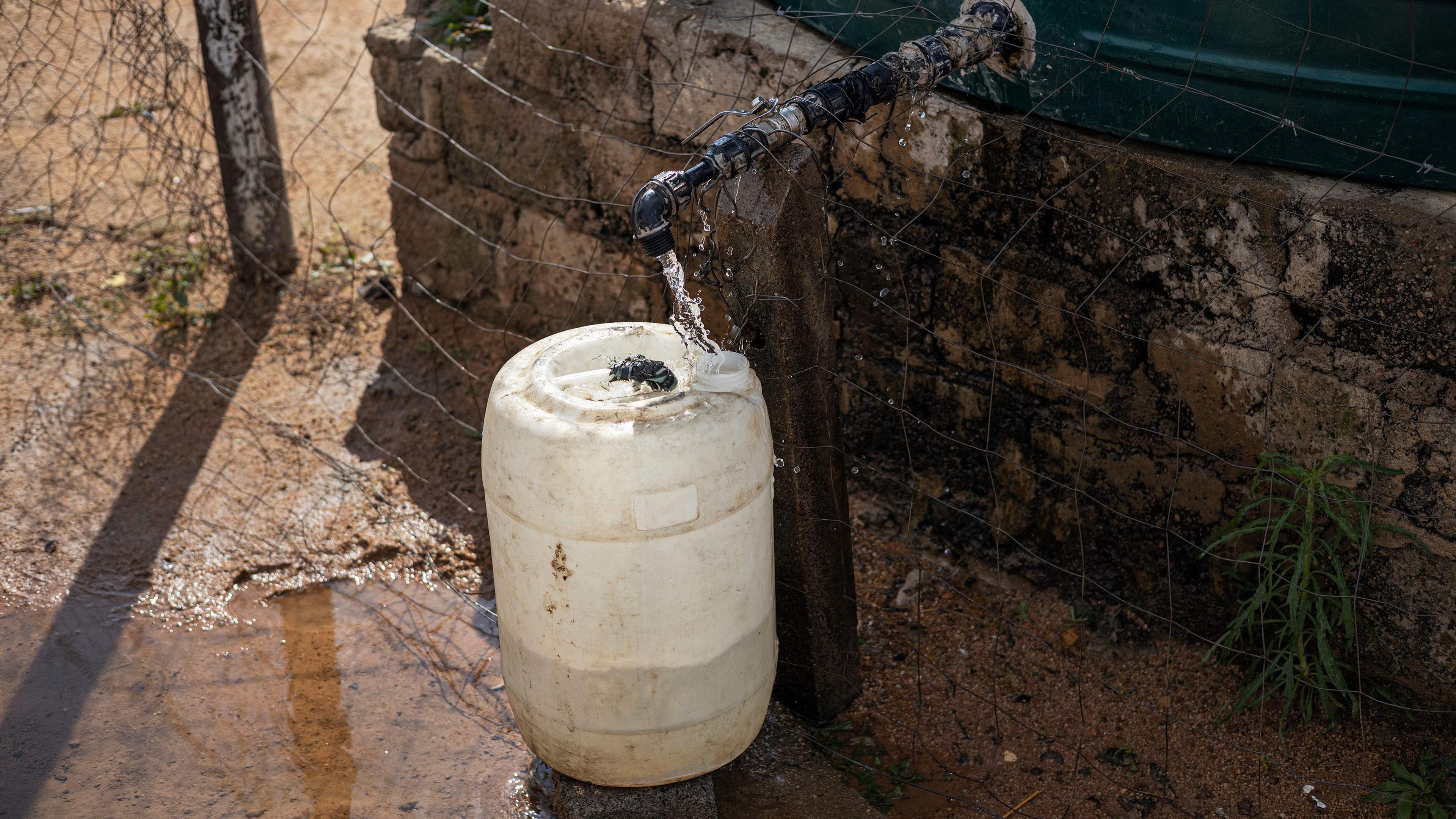 Ein Wasserkanister unter einem Wasserhahn