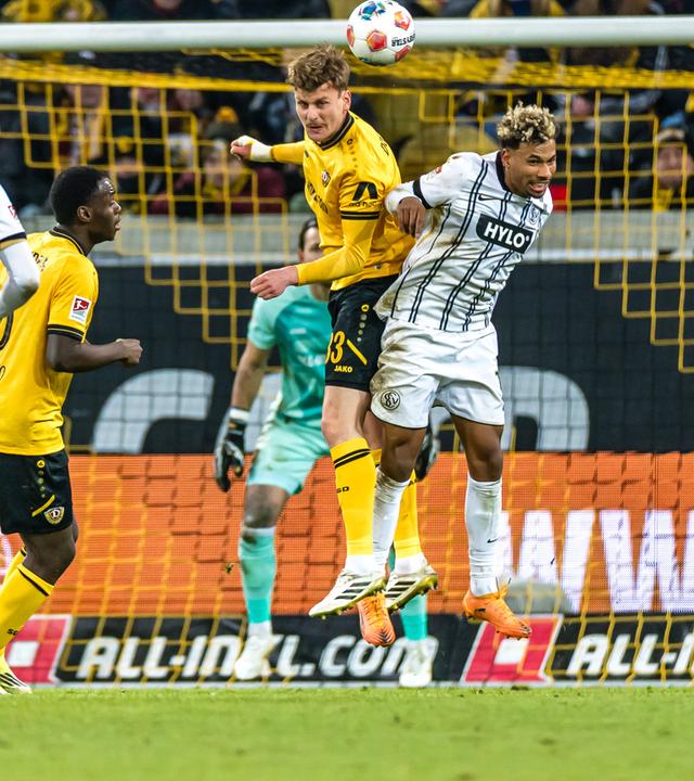 Dresdens Mittelstürmer Christoph Daferner kann im Zweikampf mit Bambasé Conté den Ball köpfen