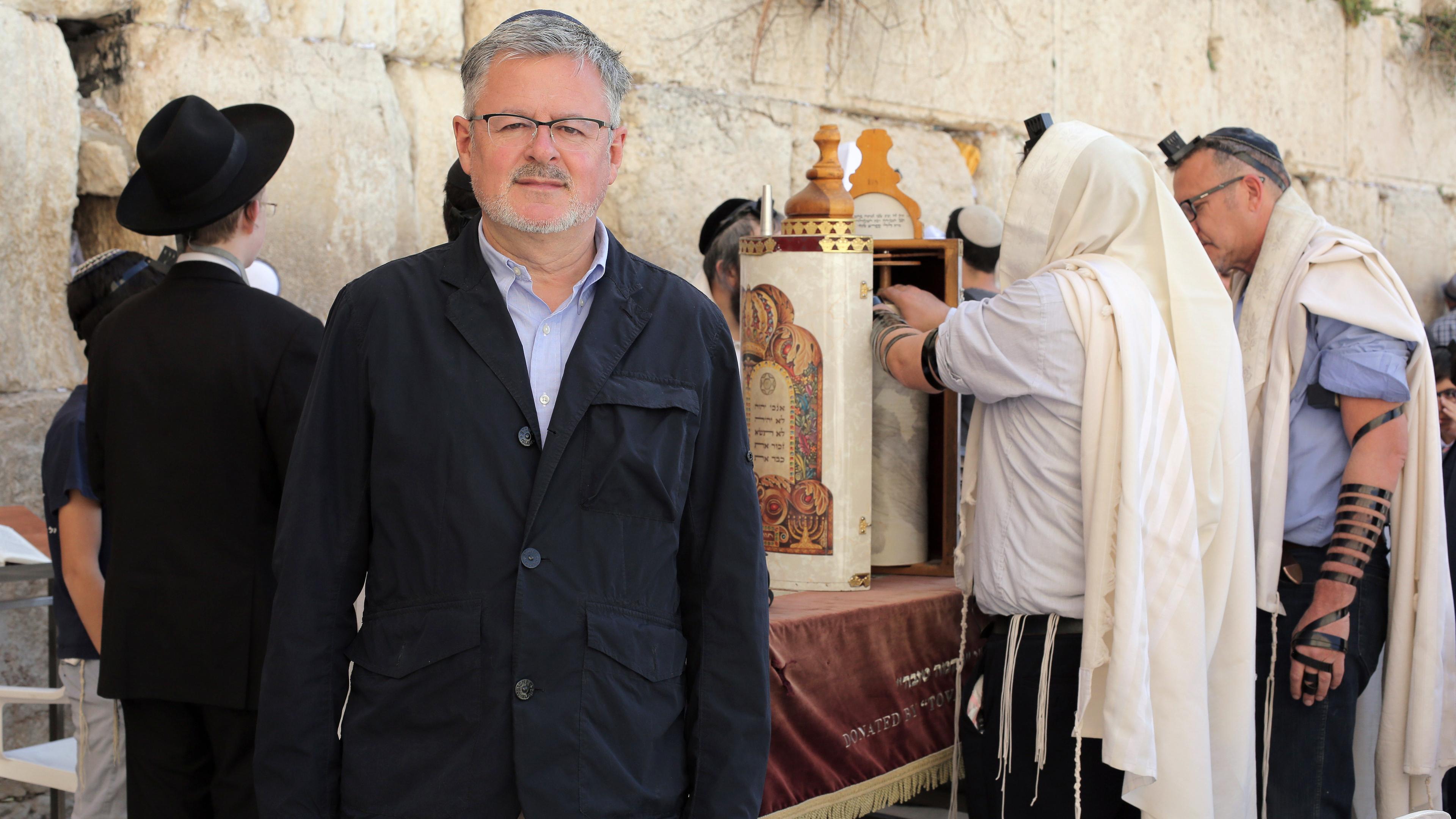 Christopher Clark steht an der Klagemauer in Jerusalem und schaut in die Kamera