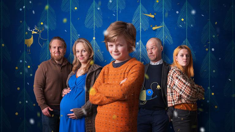 "Magische Momente - Pauls Weihnachtswunsch": Der neun Jahre alte Paul (Jeremy Miliker) steht in der Mitte des Bildes mit verschränkten Armen. Seine Patchworkfamilie bestehend aus seiner Mutter Maya (Petra Schmidt-Schaller), ihrem Freund Julius (Axel Stein), Pauls Vater Matz (Matthias Koeberlin) und Pauls Stiefschwester Lilly (Nele Trebs) stehen hinter ihm.